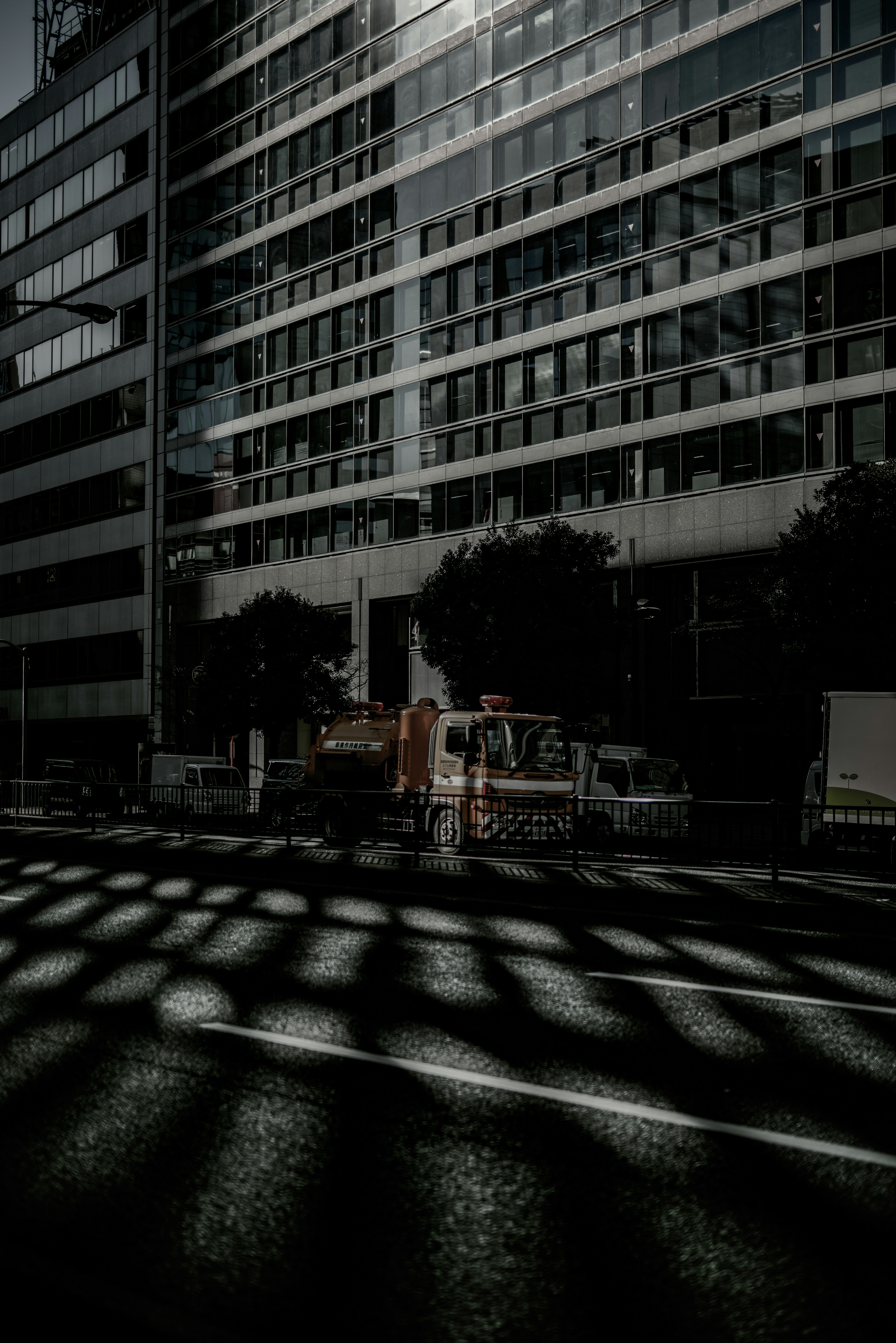 Scène urbaine avec un fort contraste entre les ombres des bâtiments et la lumière