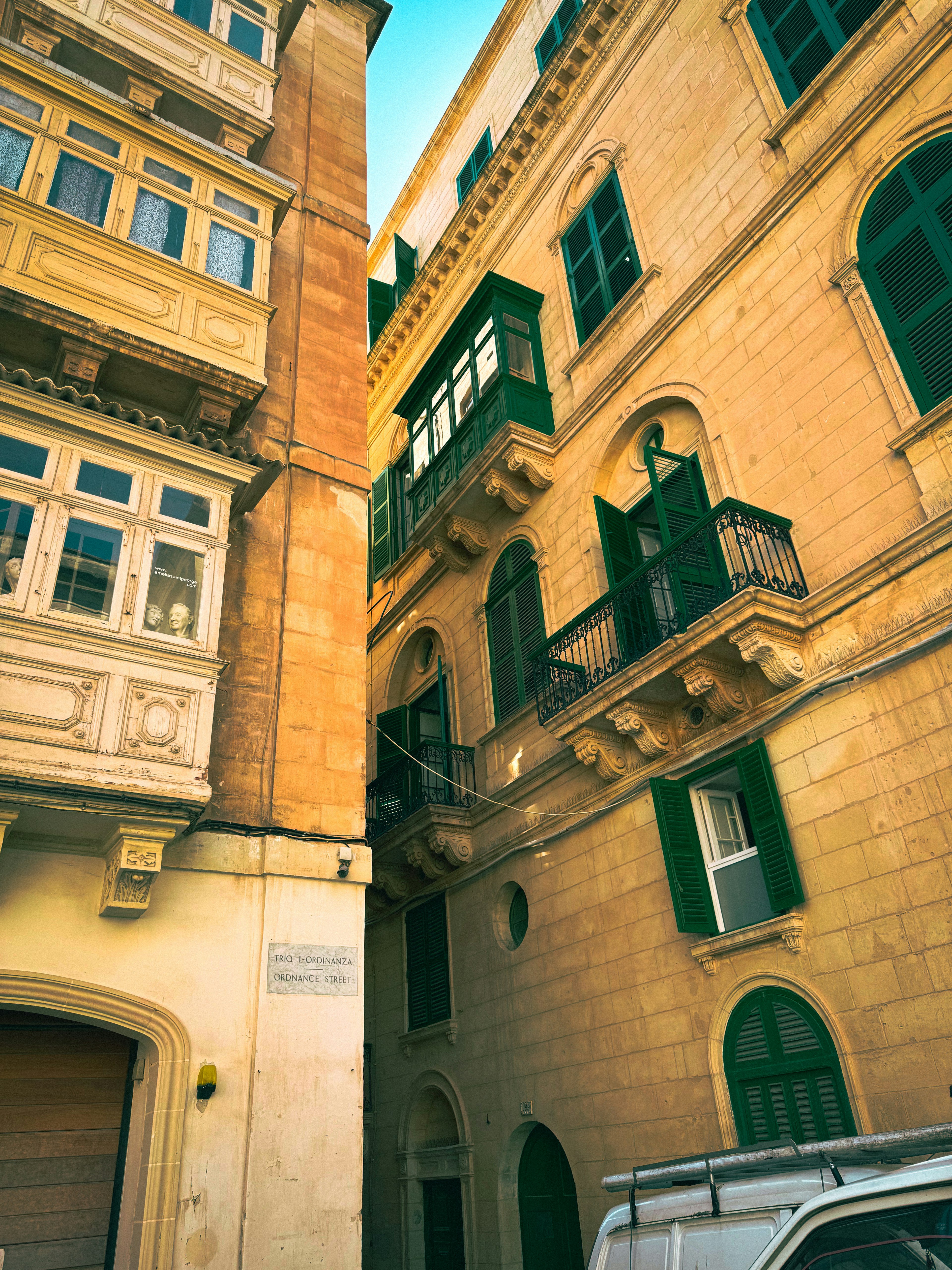 Narrow street featuring historic buildings and green windows