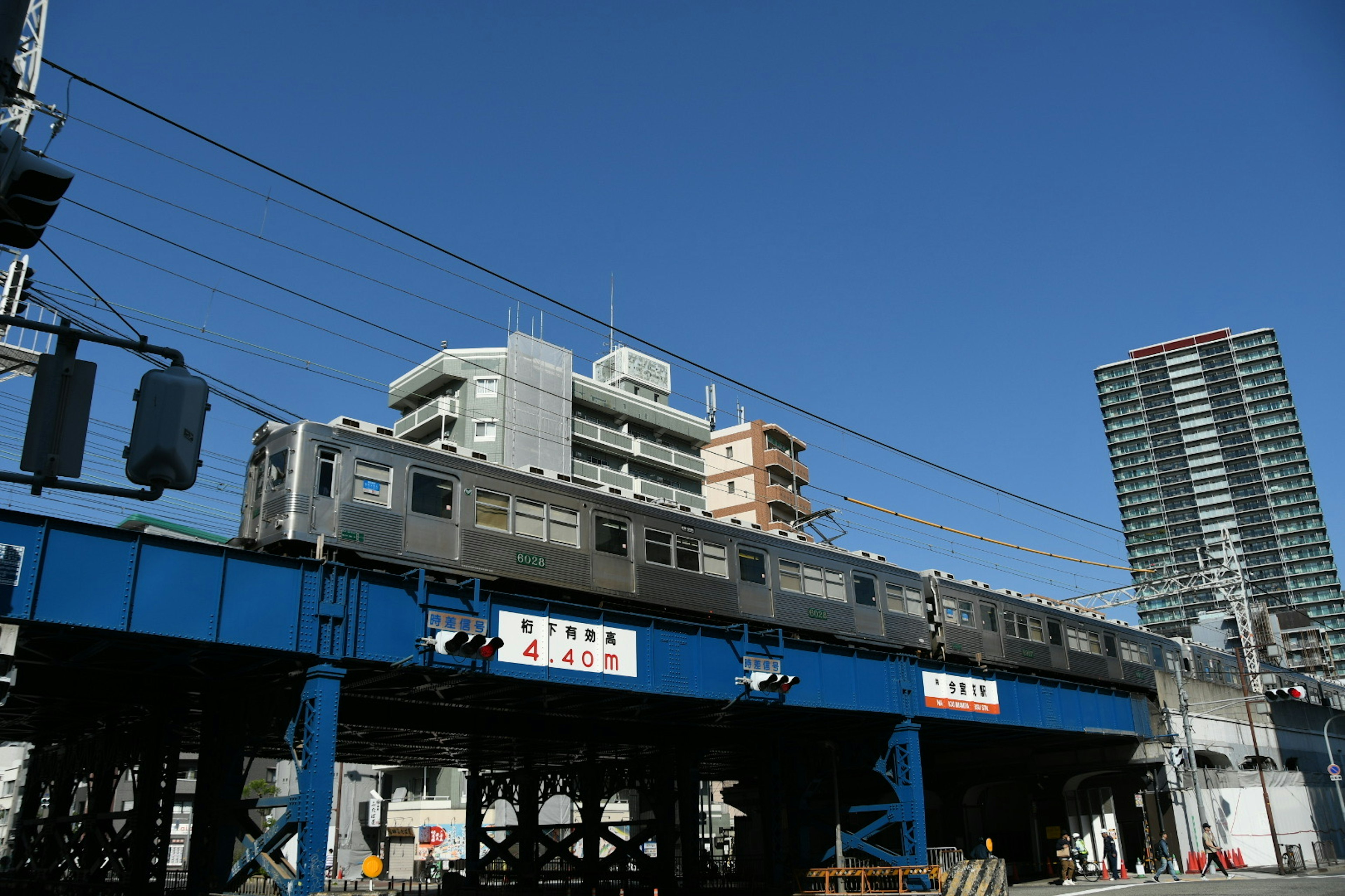 Train running under a clear blue sky with surrounding buildings