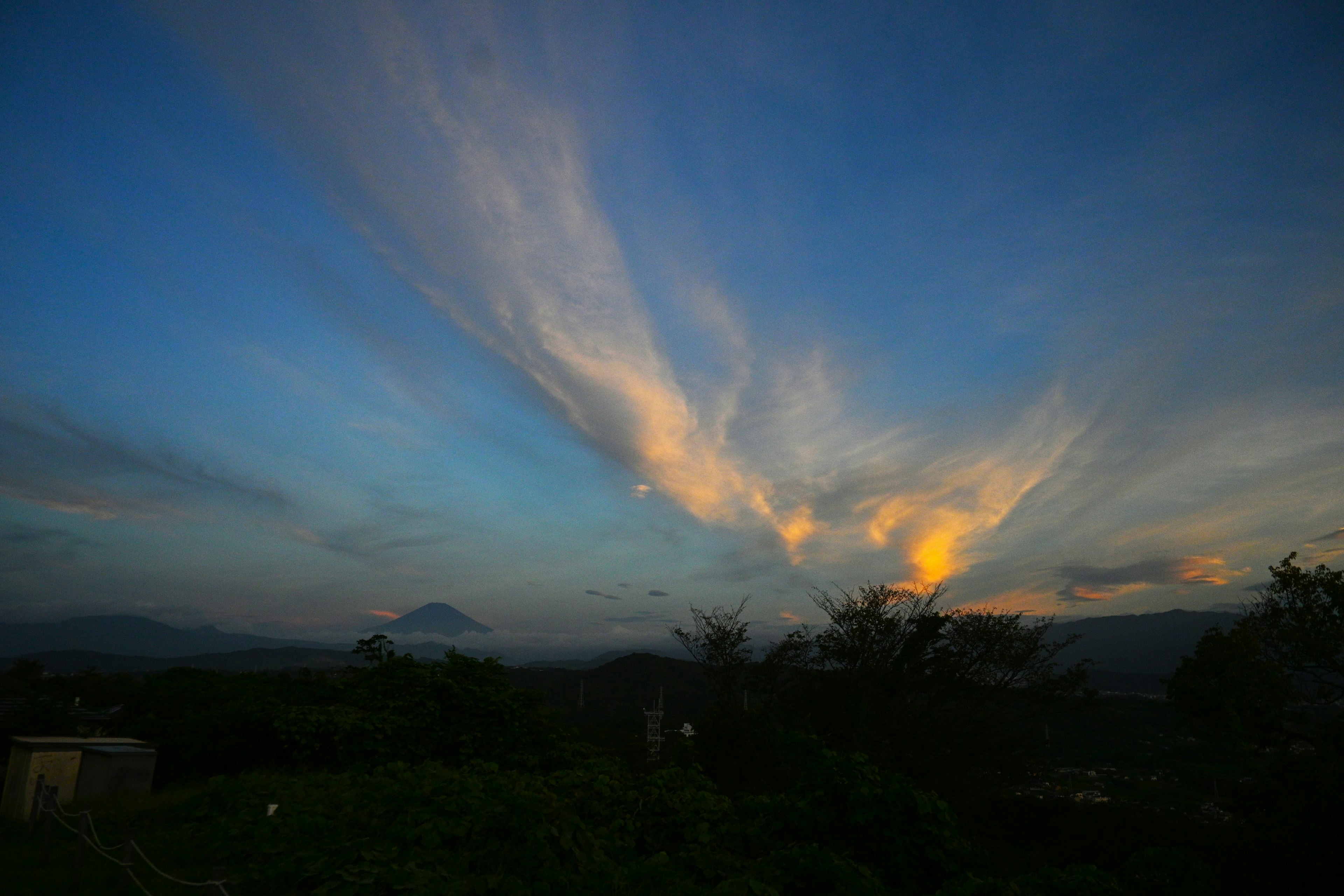 Bunter Sonnenuntergangshimmel mit wispy Wolken und fernen Bergen