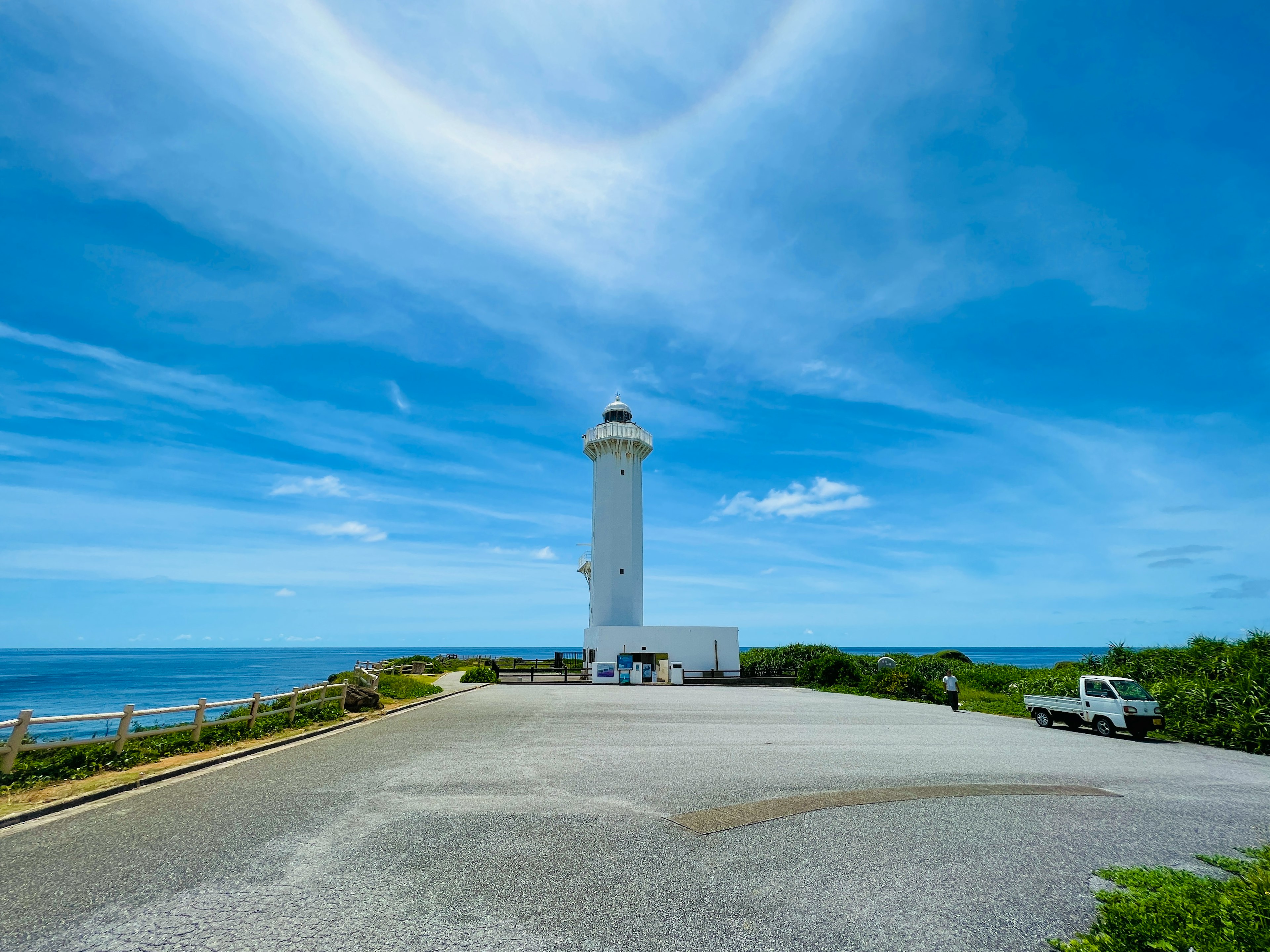 青い空と海に囲まれた白い灯台の風景