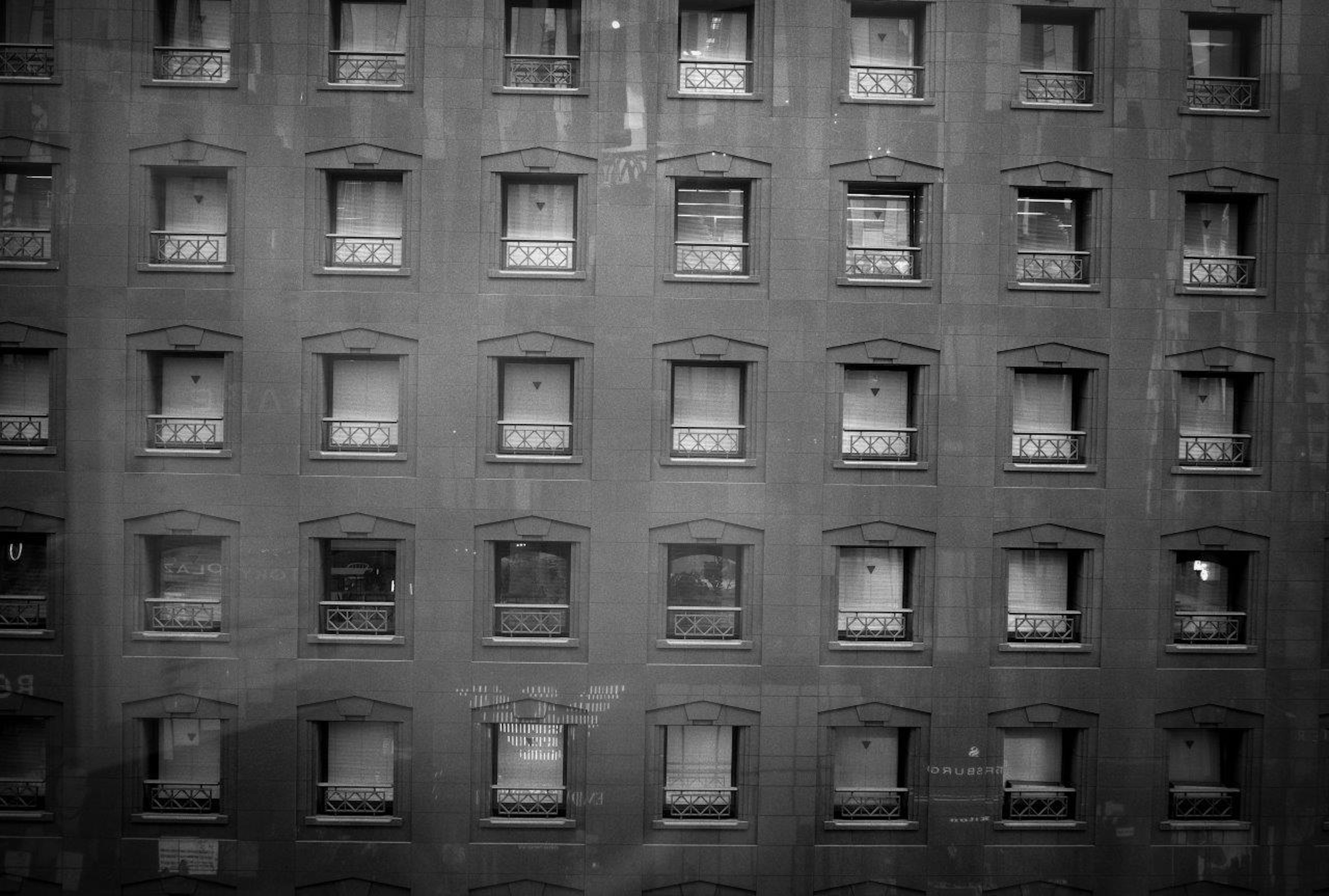 Vista detallada de las ventanas en una fachada de ladrillo en blanco y negro