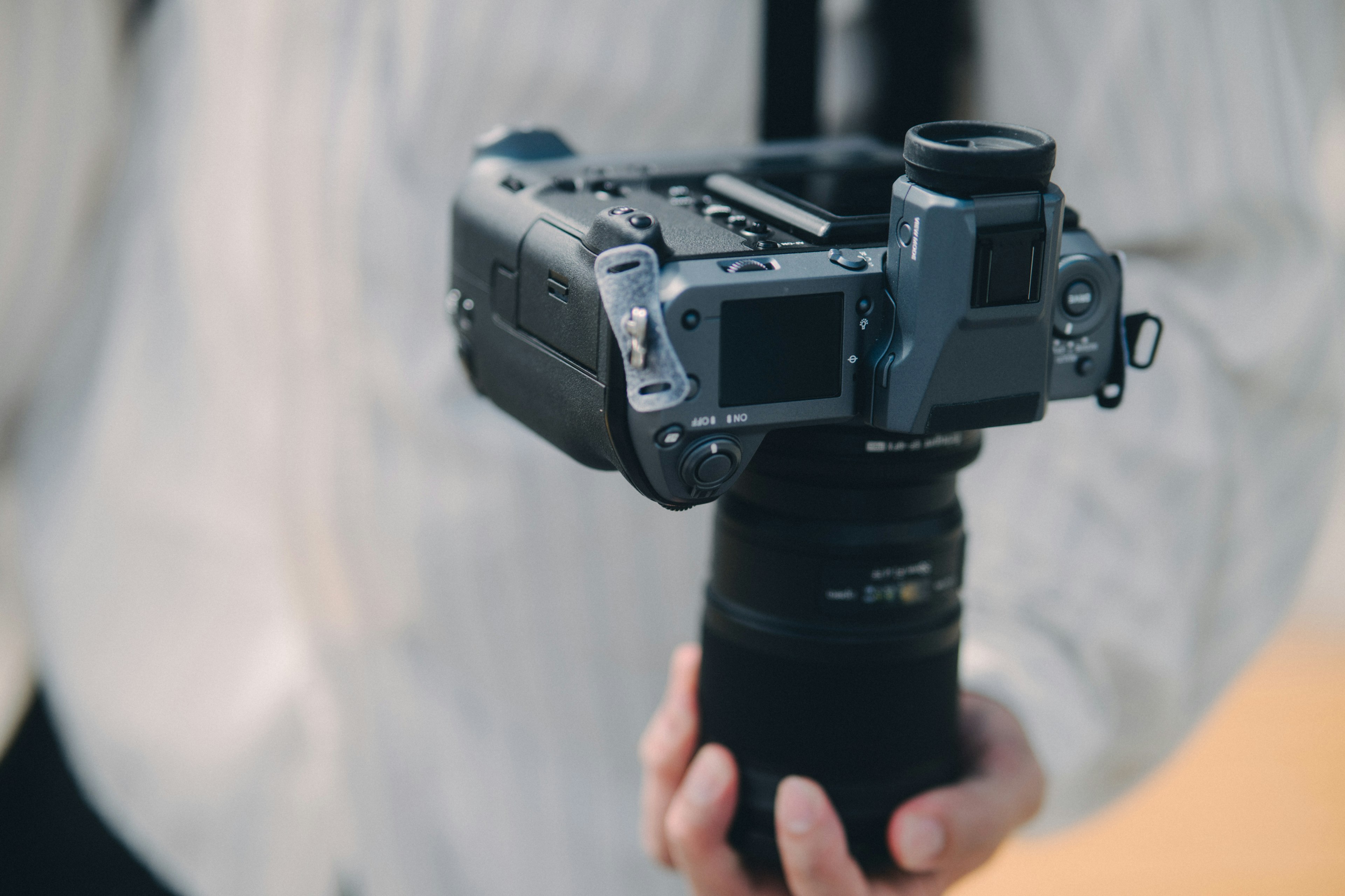 A person holding a camera with a large lens