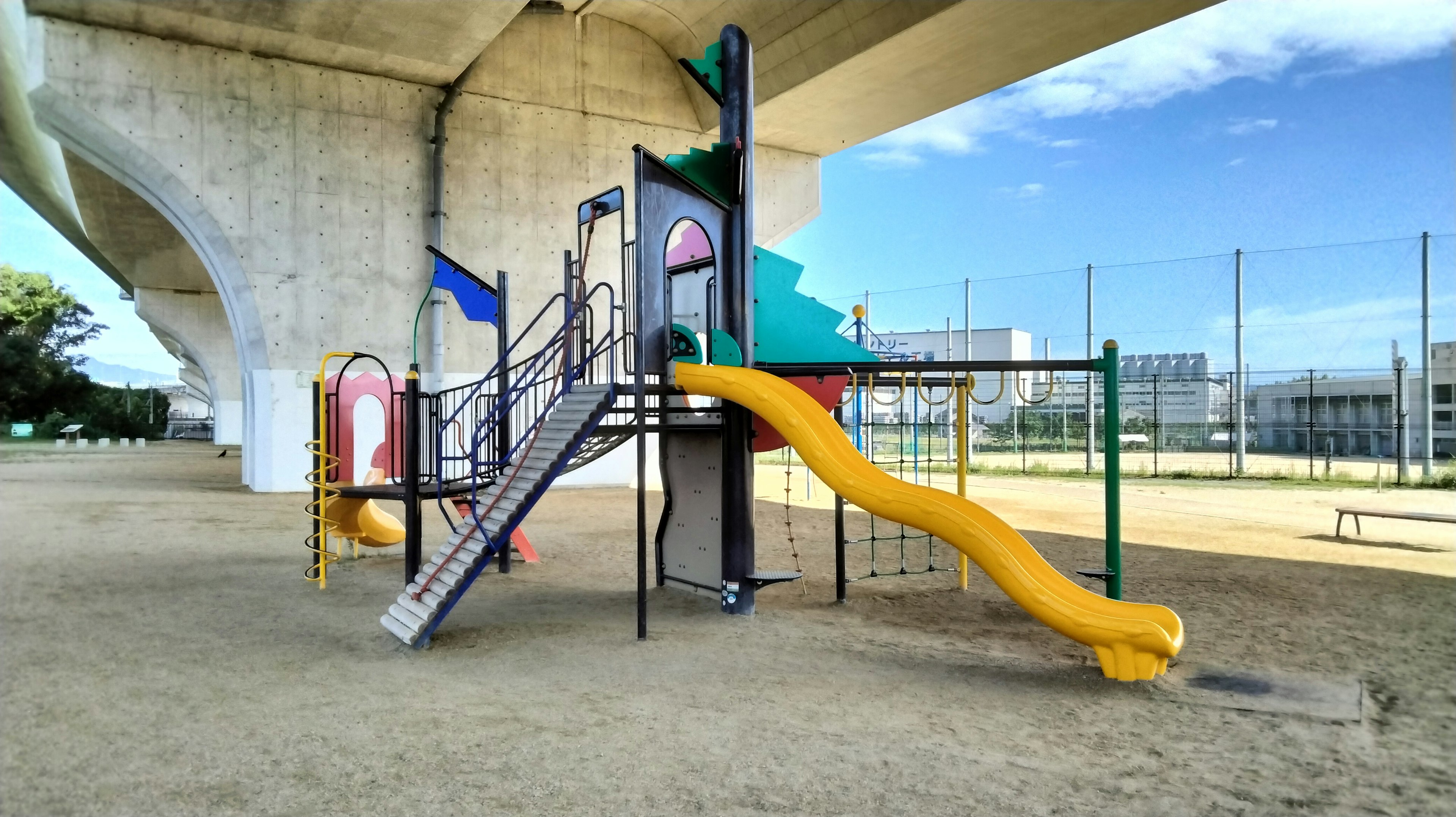 Escena de un parque infantil con un tobogán y escaleras