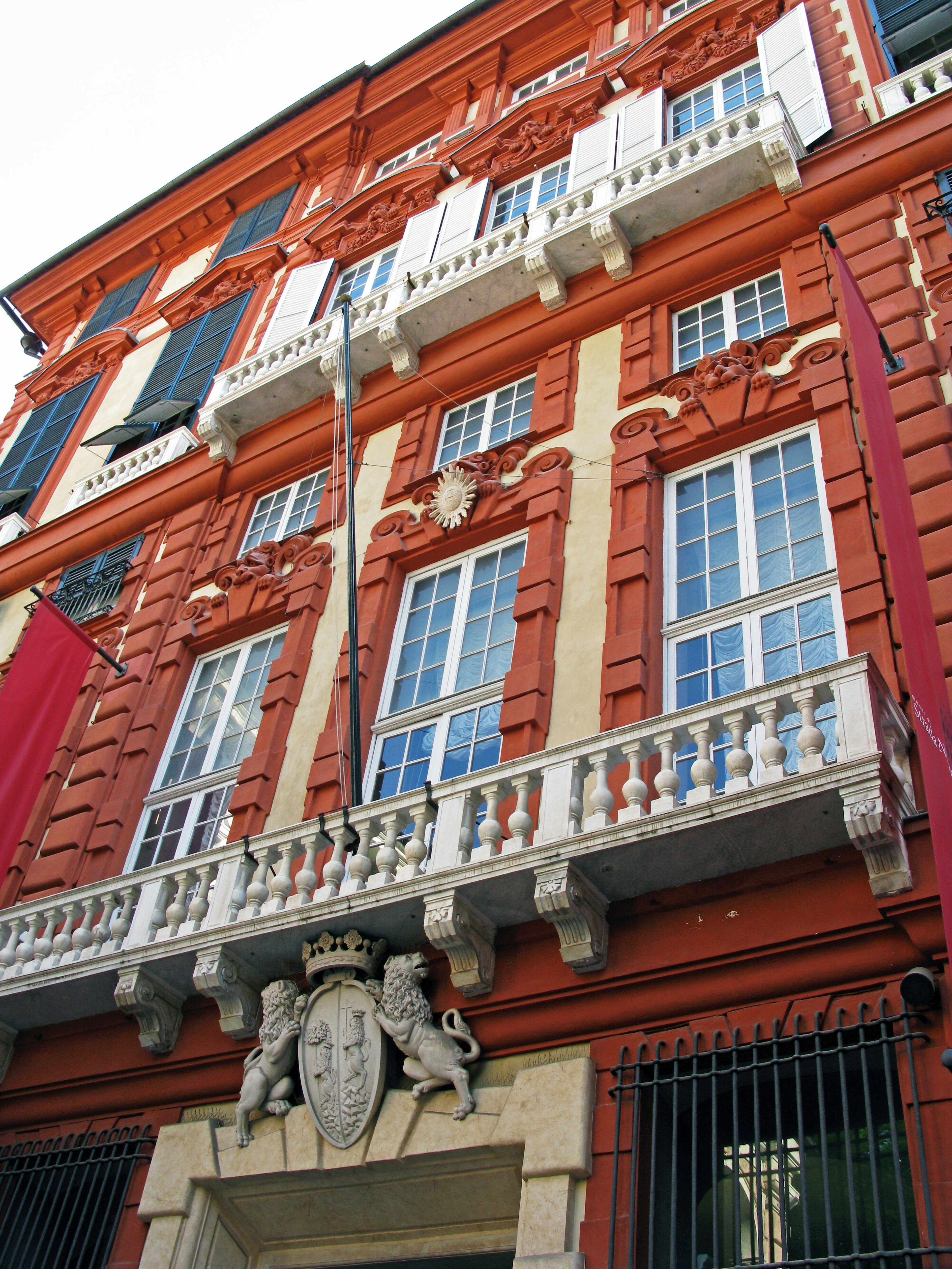 Façade d'un bâtiment historique avec une extérieur rouge et des balcons blancs