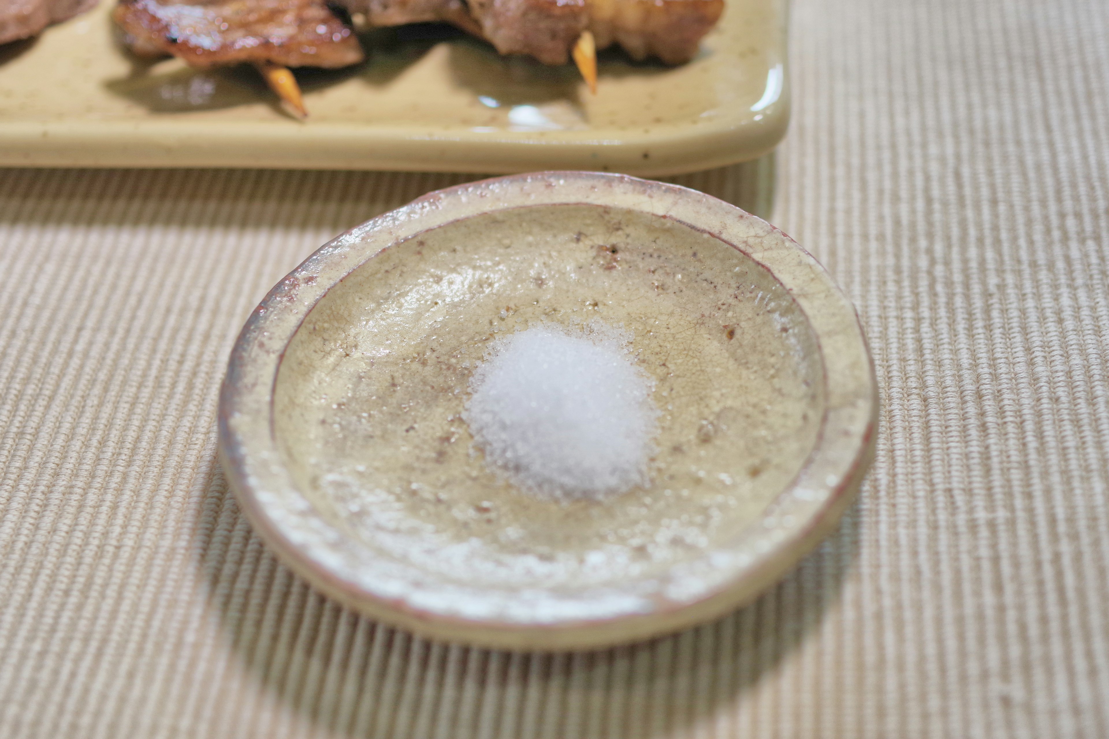 A small ceramic dish with salt placed on a table