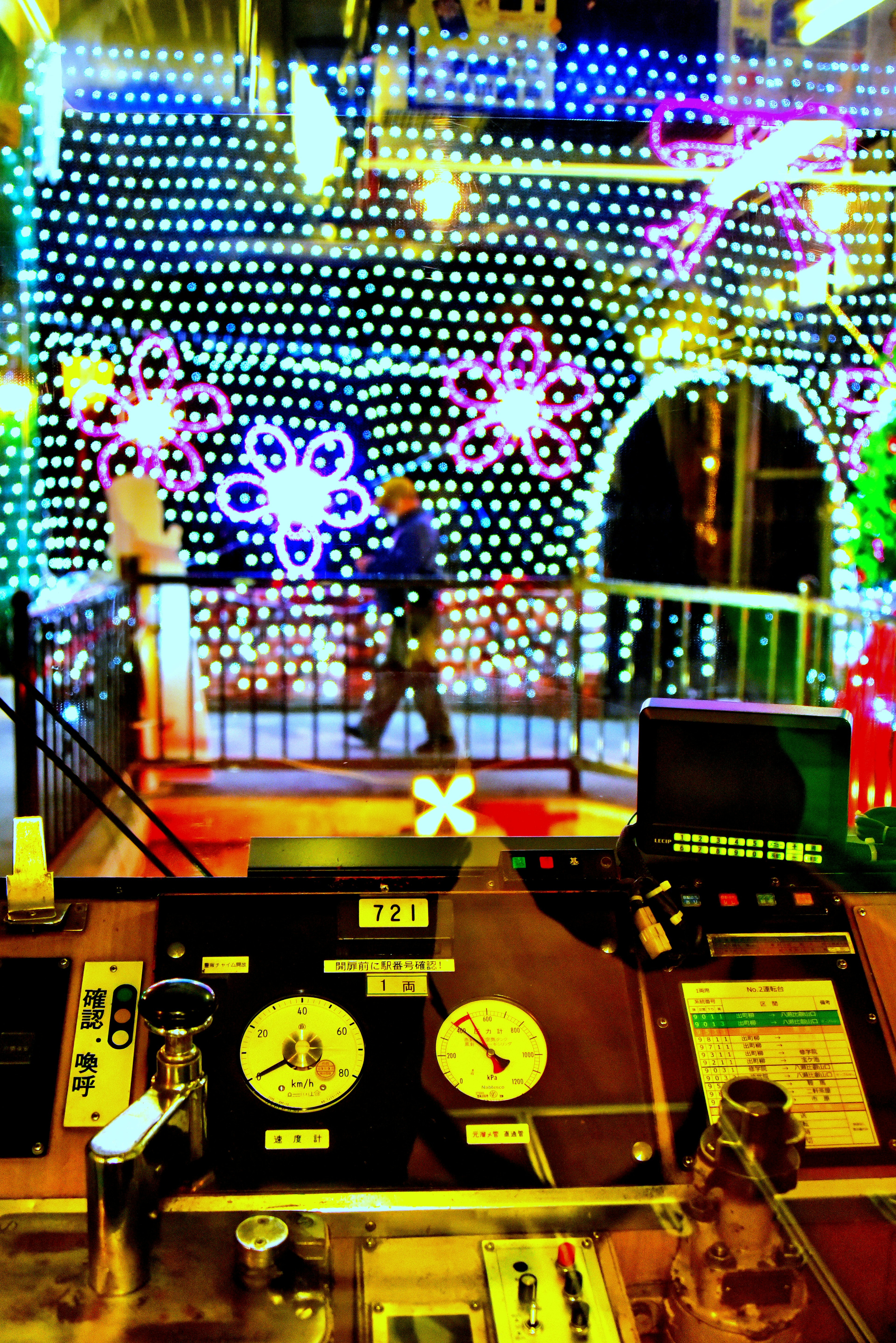 Brightly lit building decorated with colorful lights and people walking