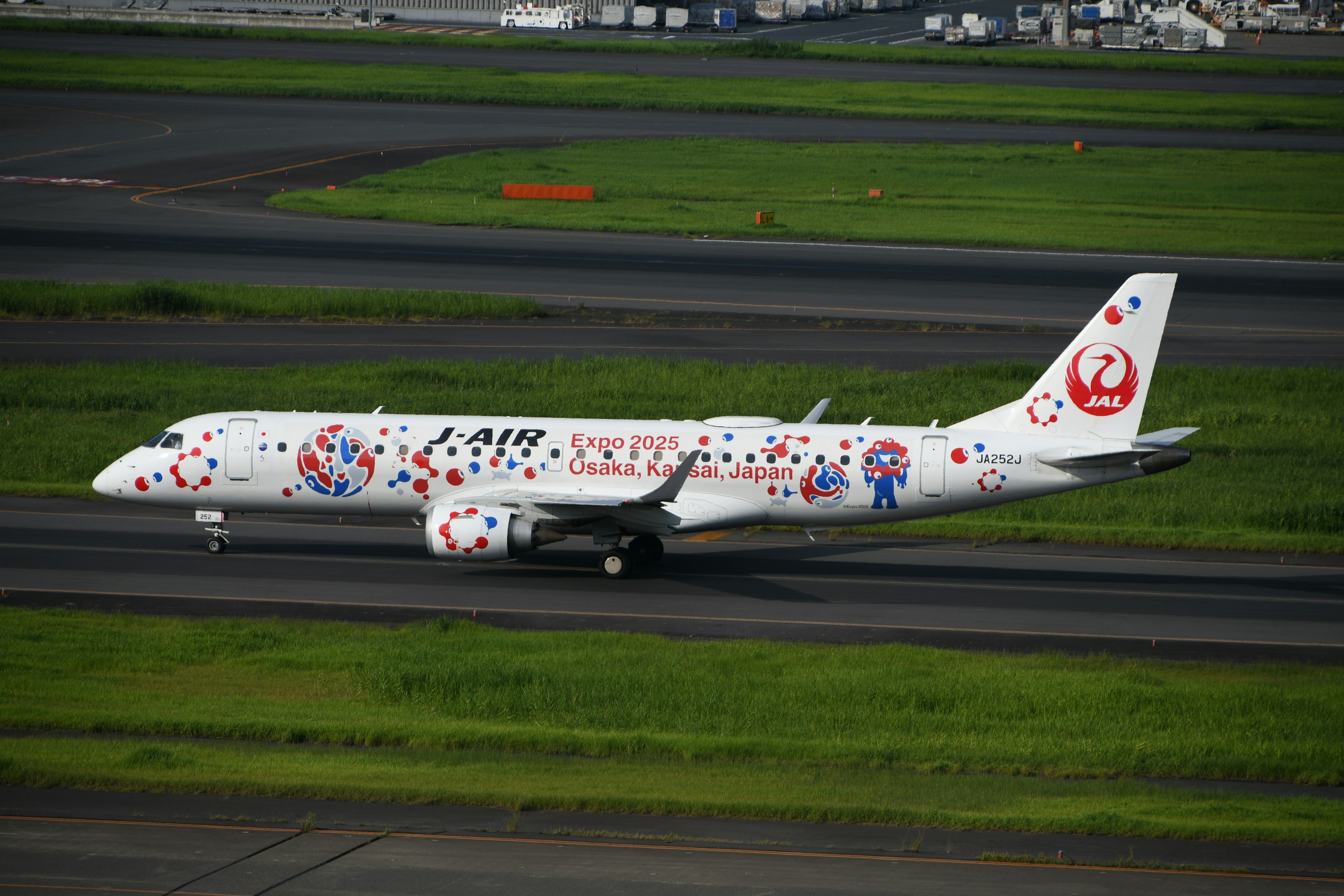 白いボディにカラフルなデザインの航空機が滑走路を走行中