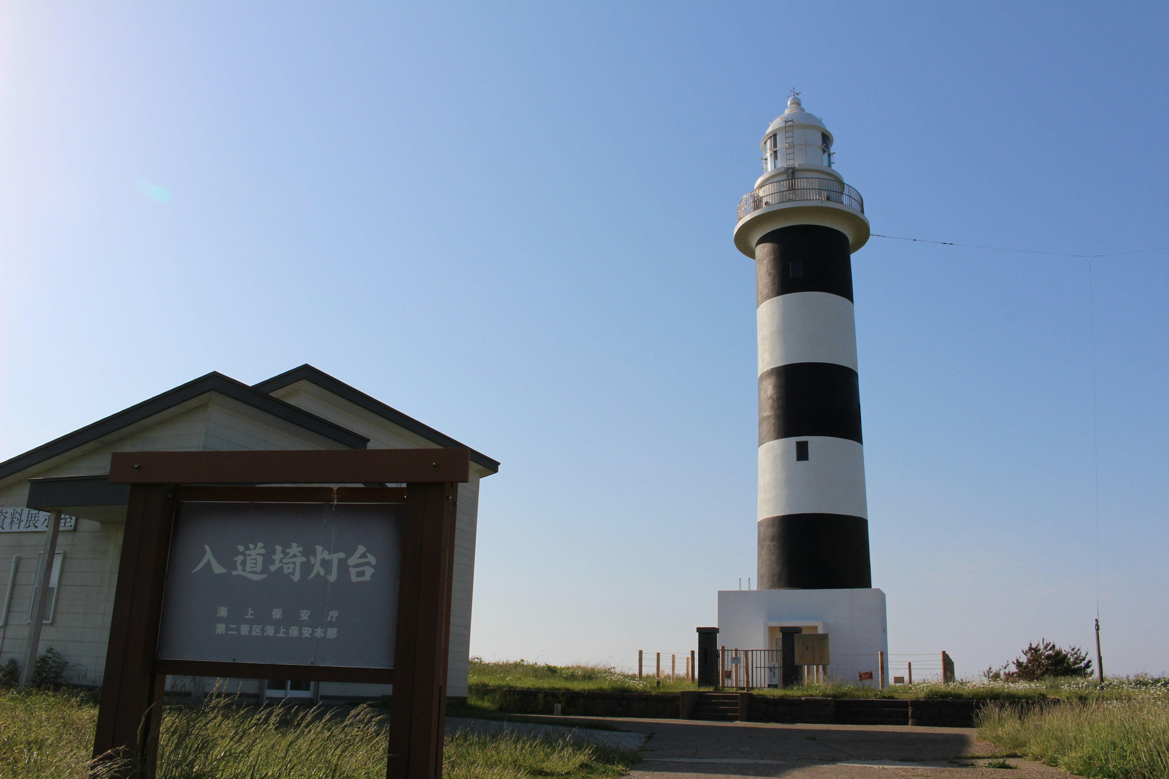 Black and white striped lighthouse next to a building