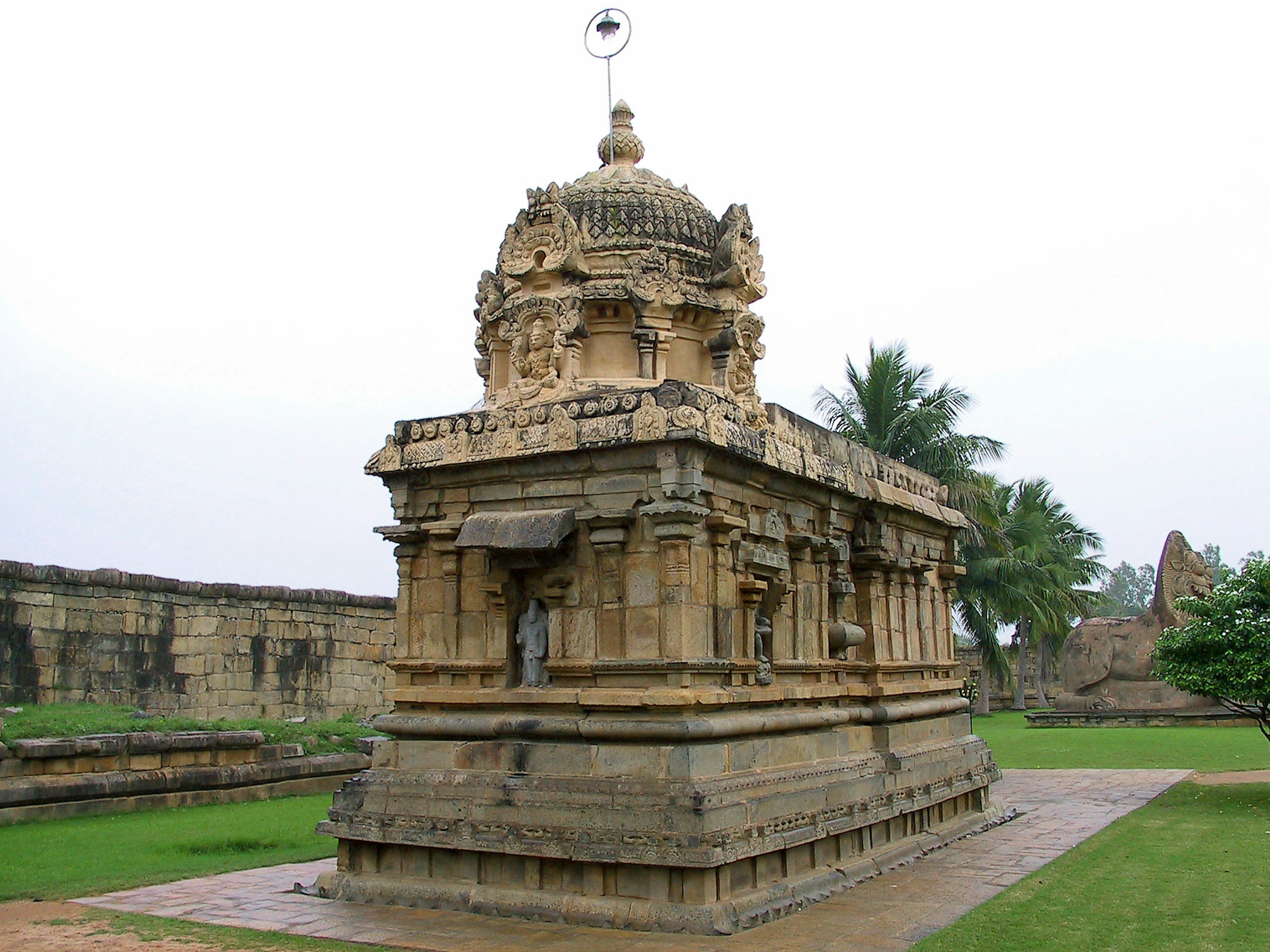 Ancient stone temple structure surrounded by green grass and trees