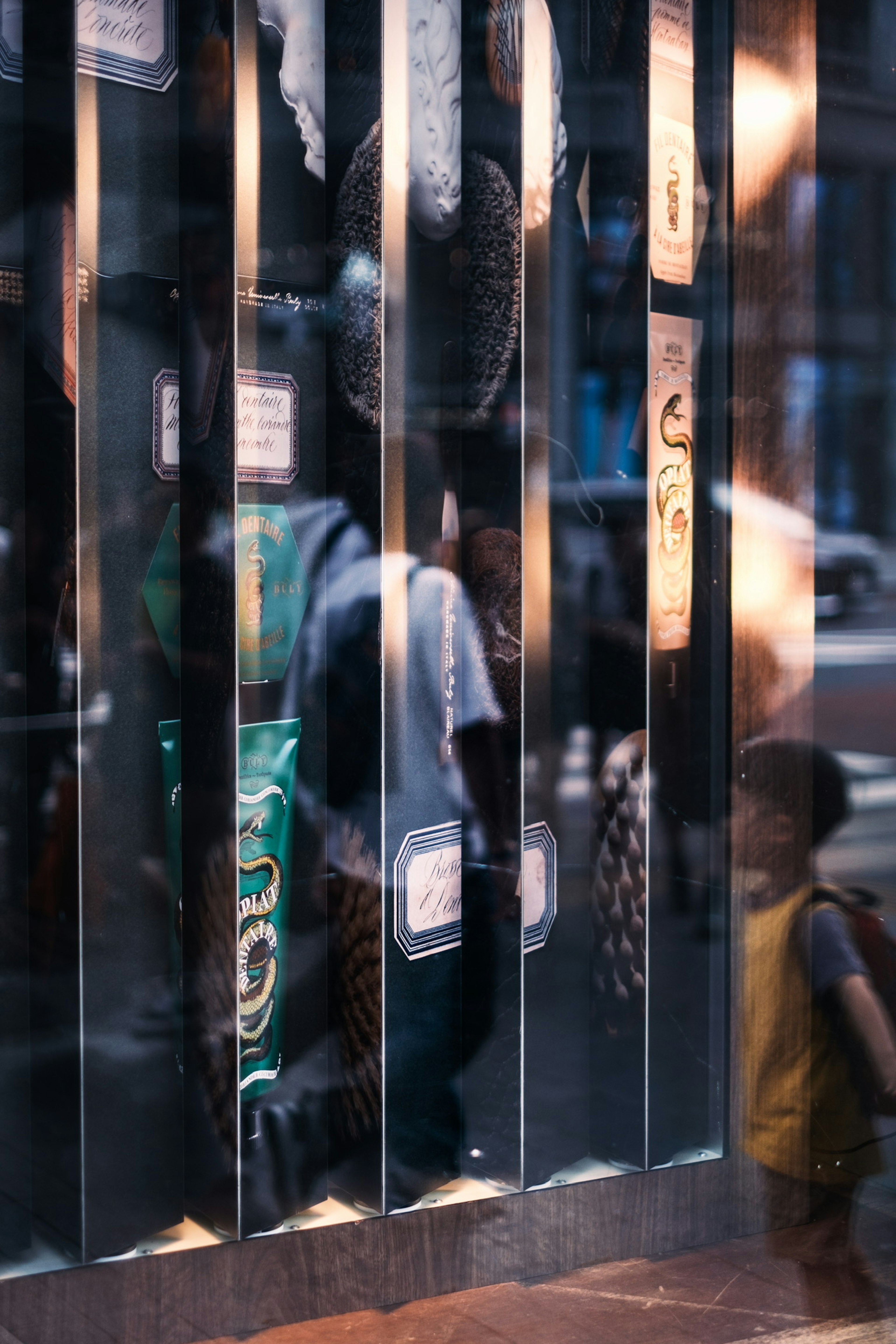 Straßenszene mit Silhouetten eines Kindes und eines Erwachsenen, die in einem Fenster reflektiert werden