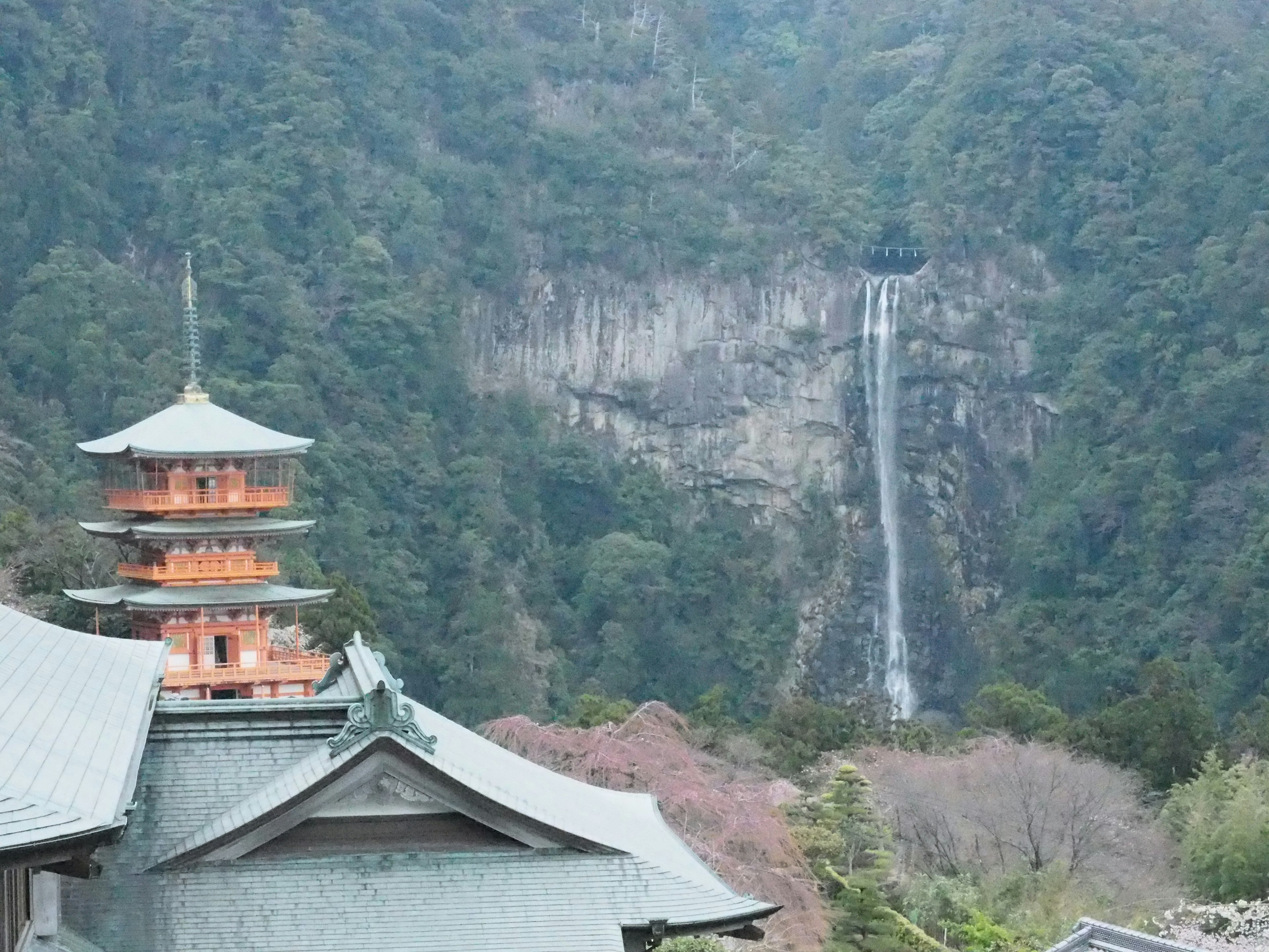 Mountain landscape featuring a waterfall and temple