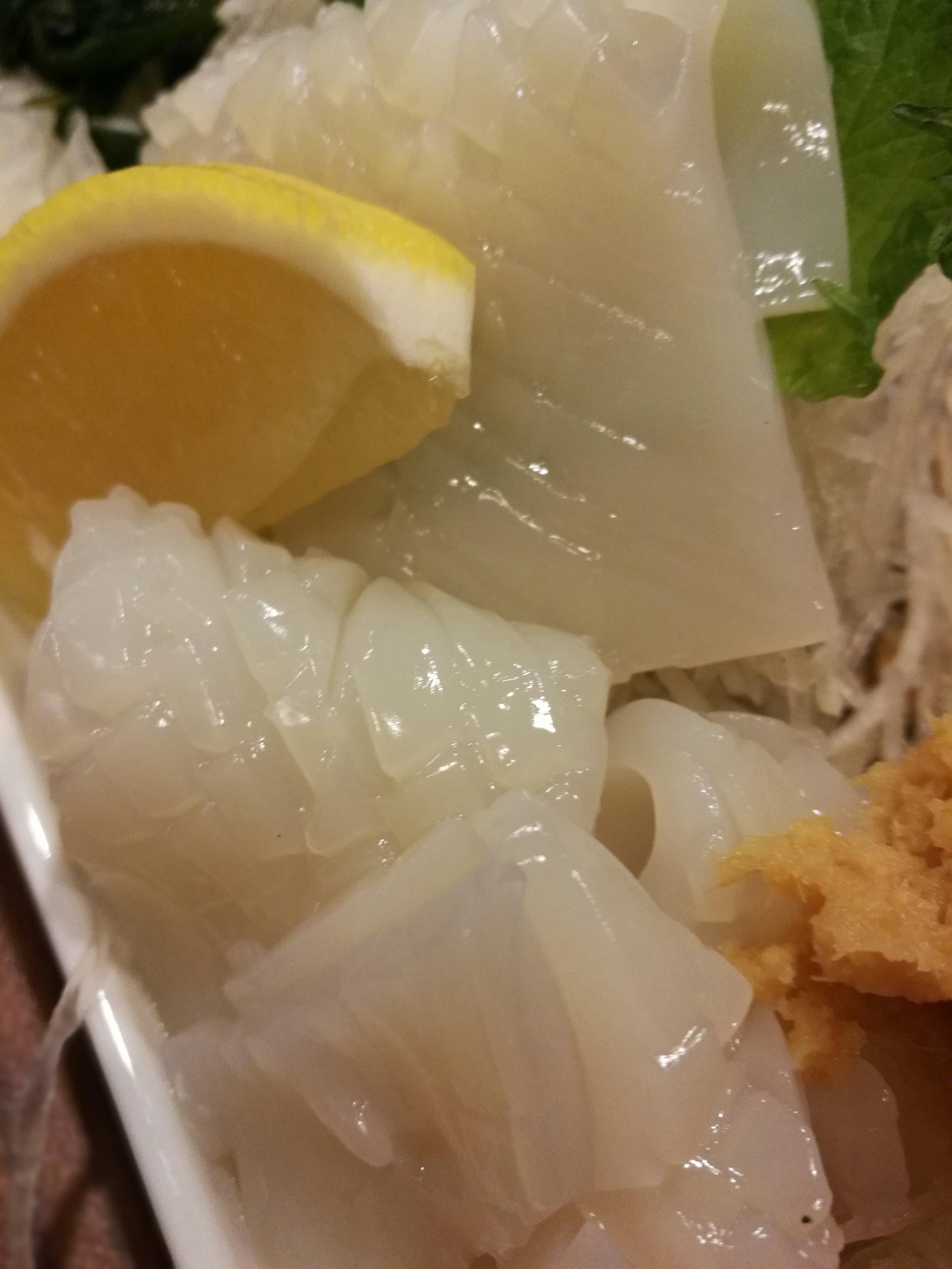 Fresh squid sashimi with a slice of lemon