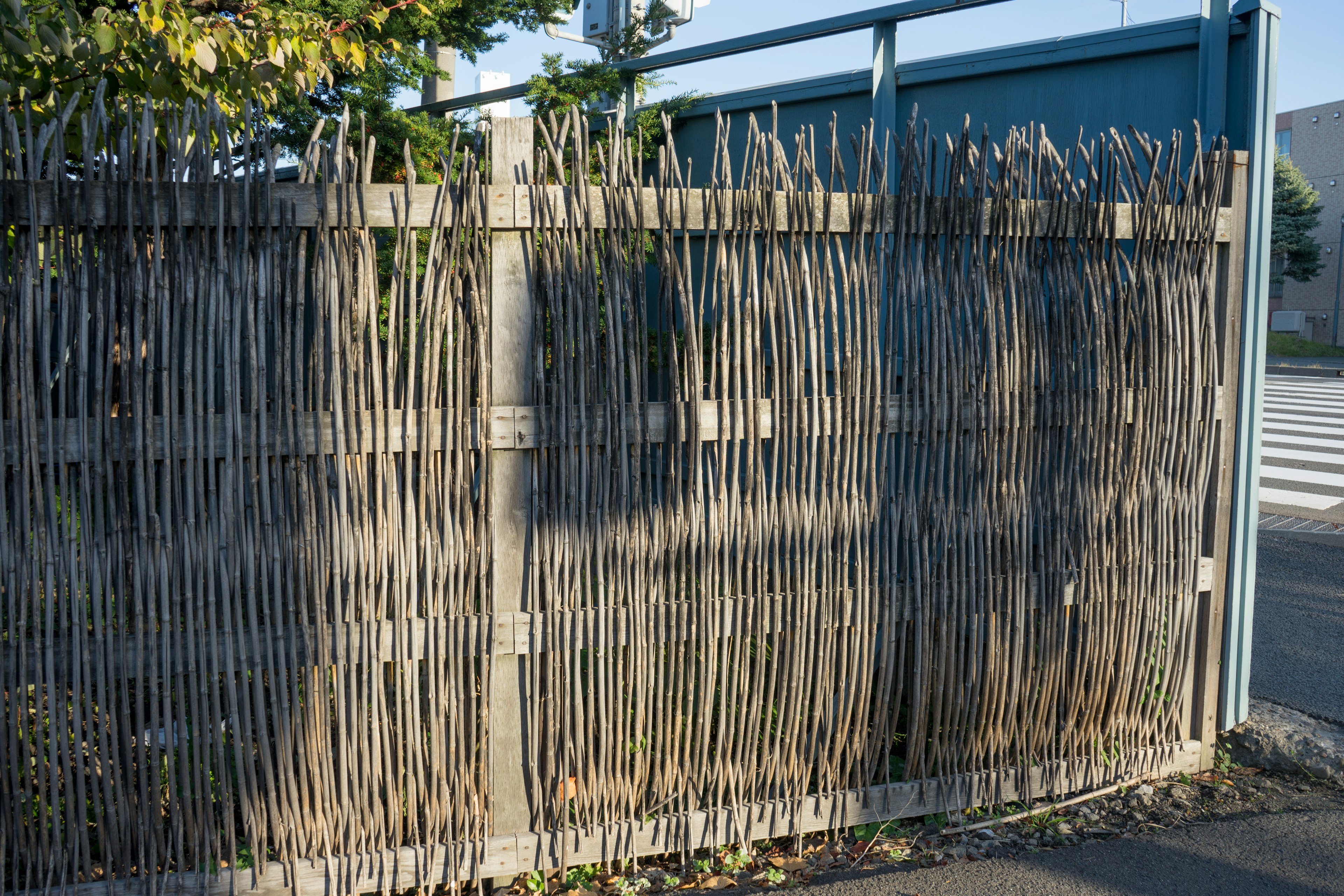 A wooden fence standing in front of a blue wall