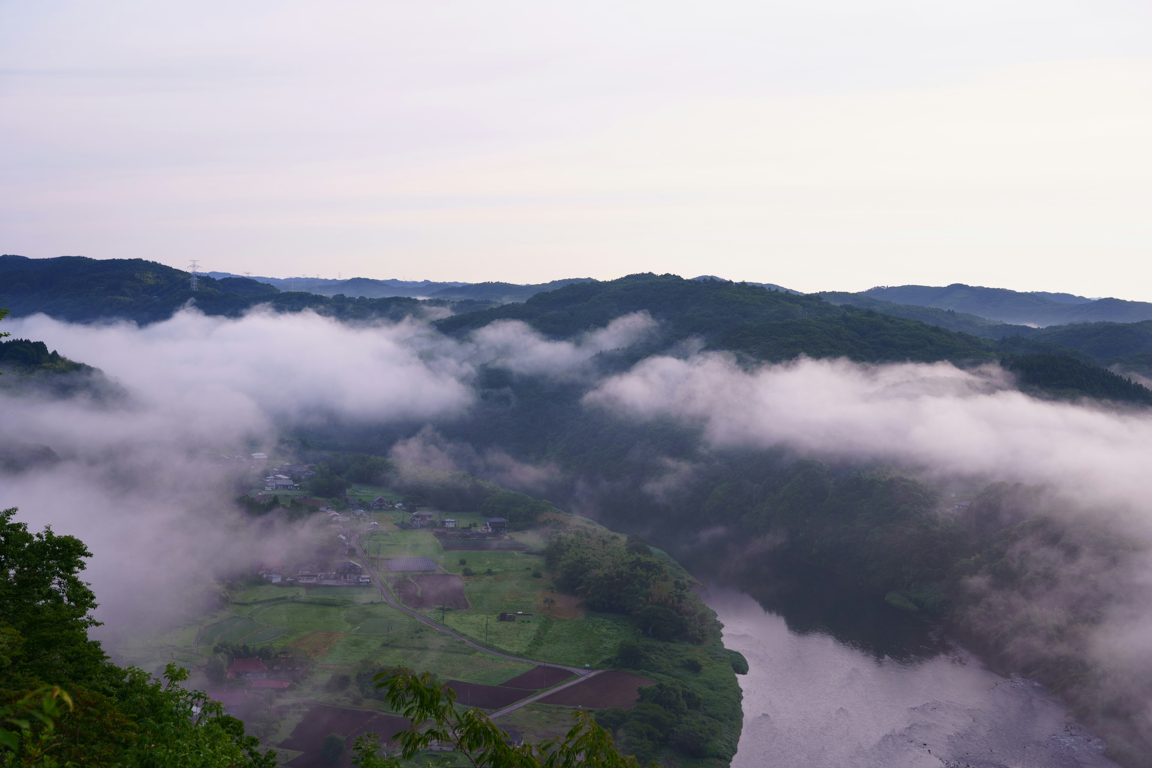 霧に包まれた山々と川の美しい風景