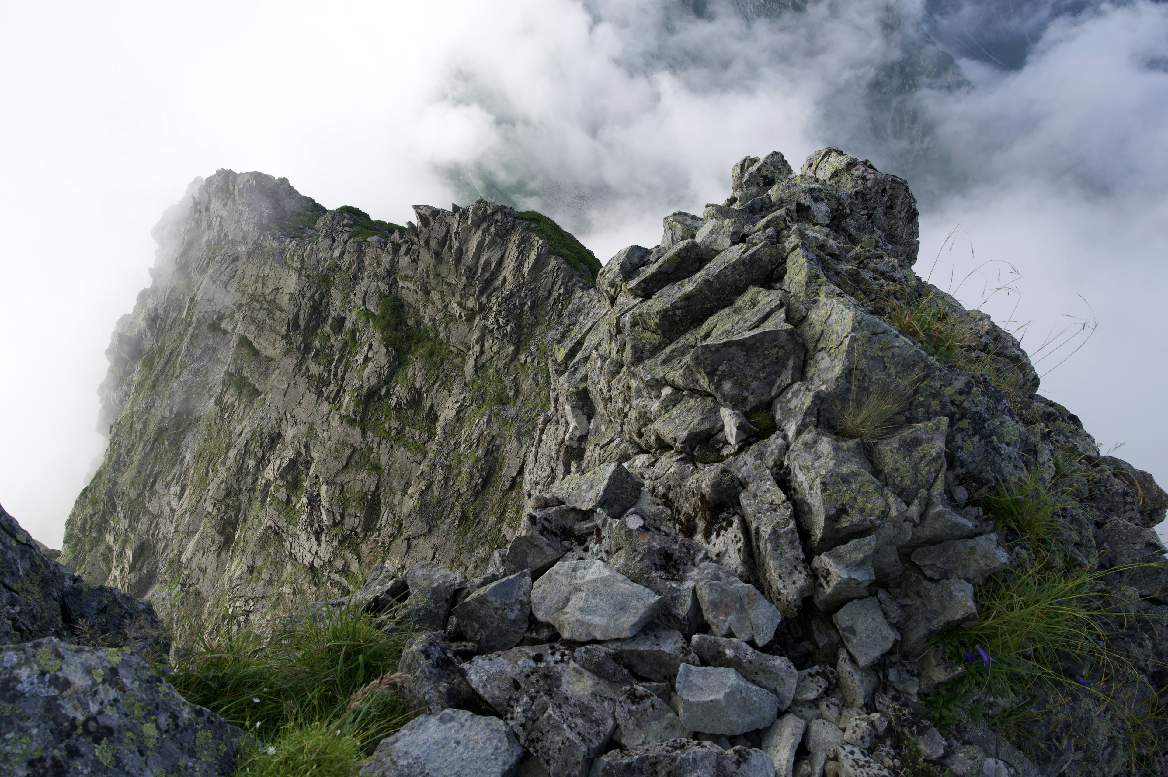 Sommet montagneux rocheux entouré de nuages