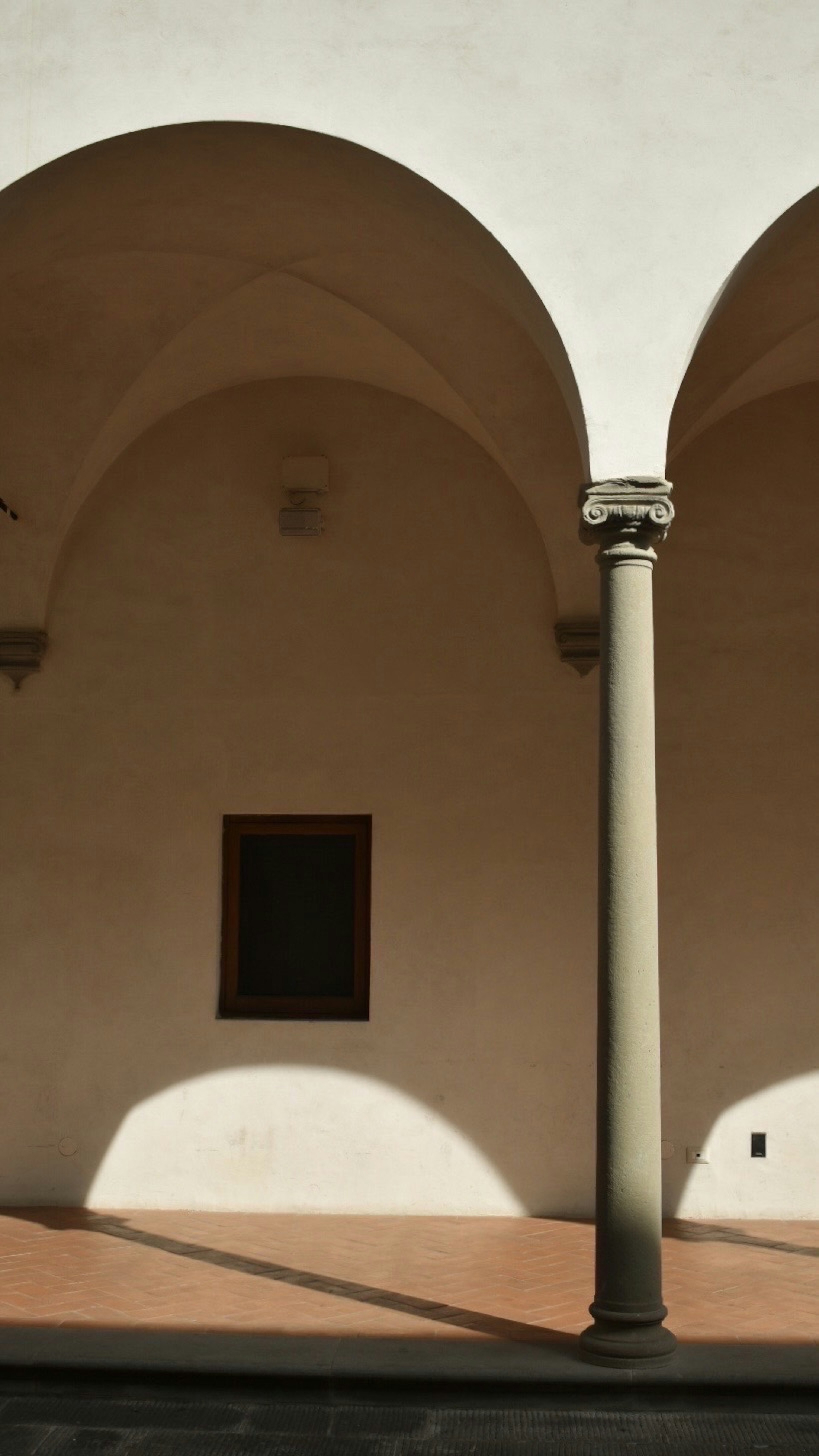 Quiet arcade wall with arching ceiling and column