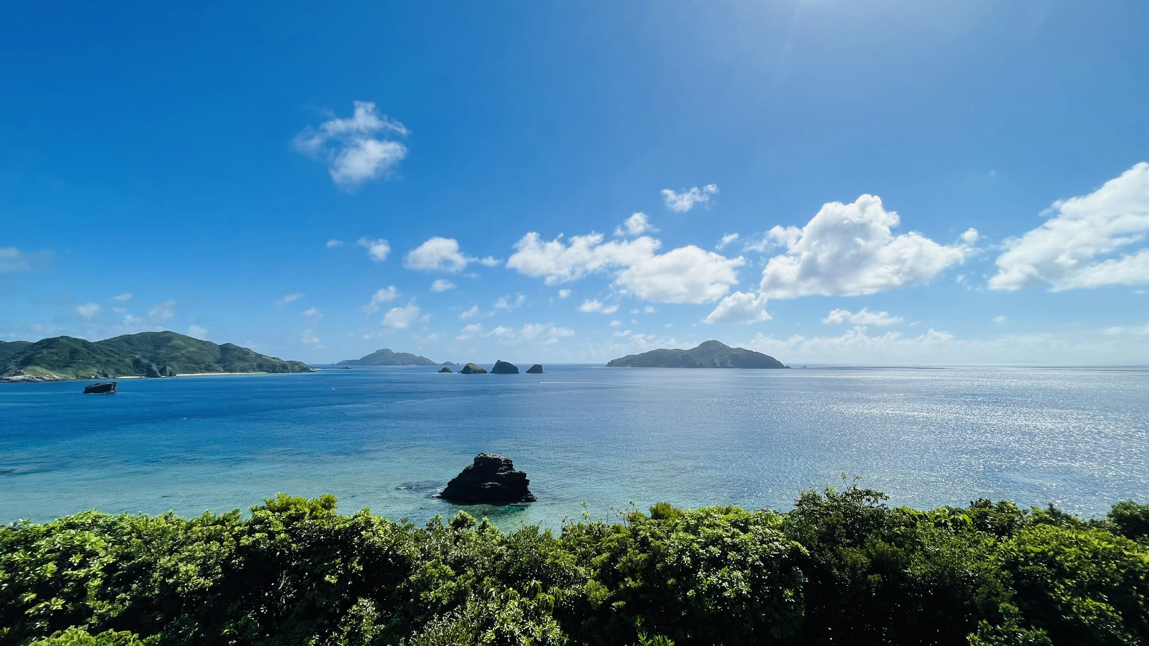 Magnifique paysage de mer et ciel bleus avec de la verdure au premier plan et des îles au loin