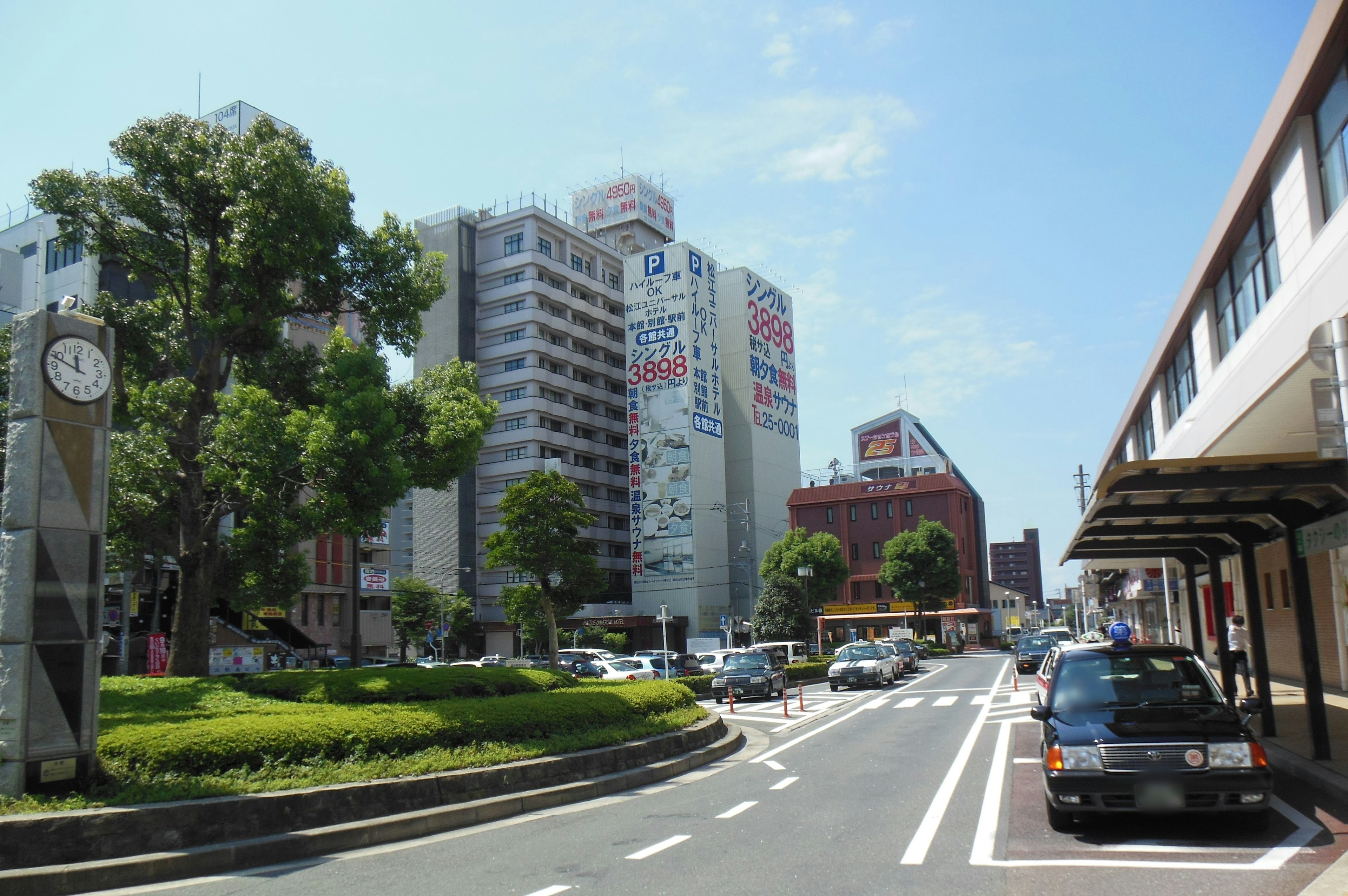 Urban landscape featuring tall buildings and green park under blue sky