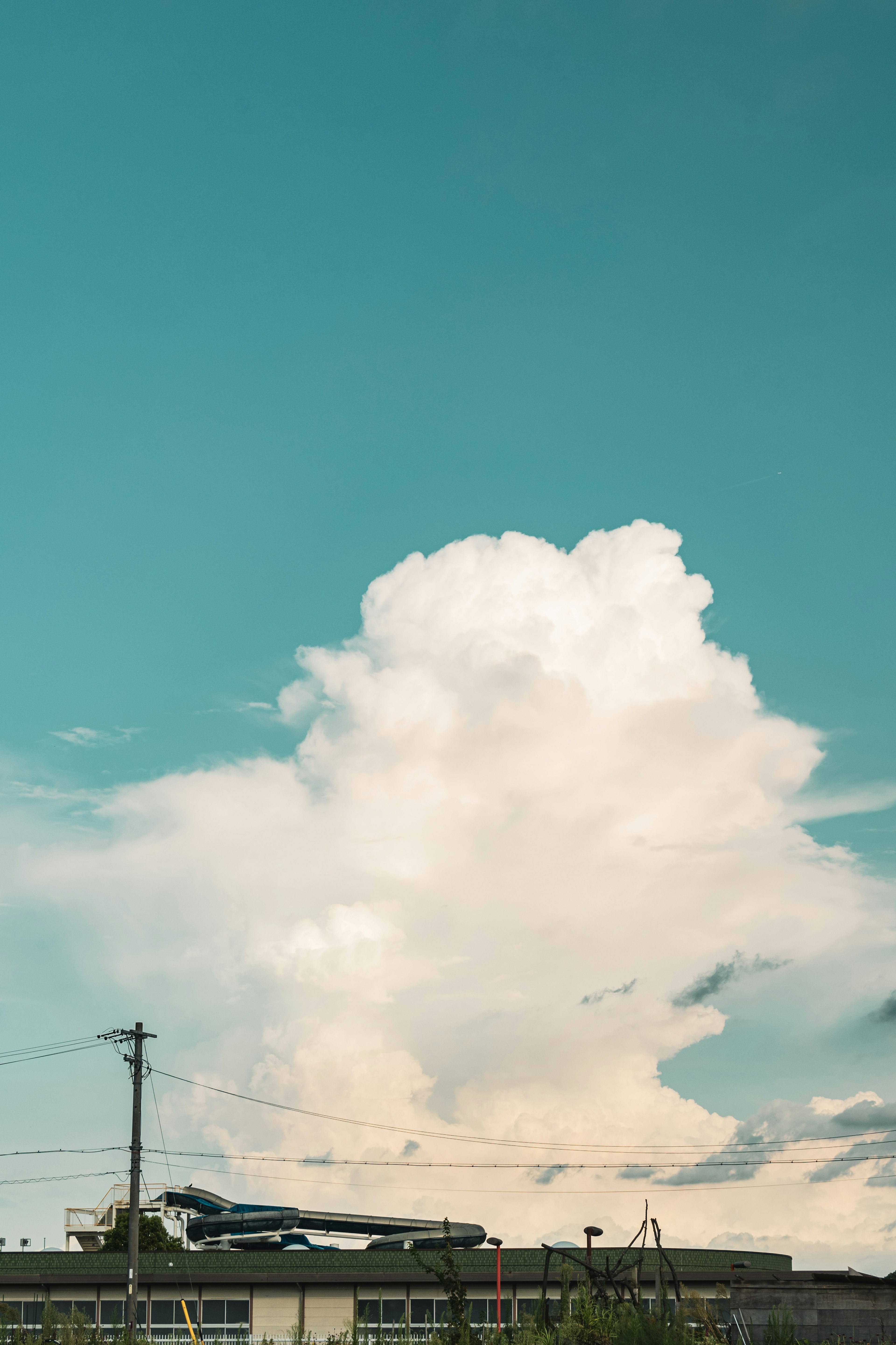 Nuage blanc duveteux sur fond de ciel bleu clair avec silhouettes de bâtiments