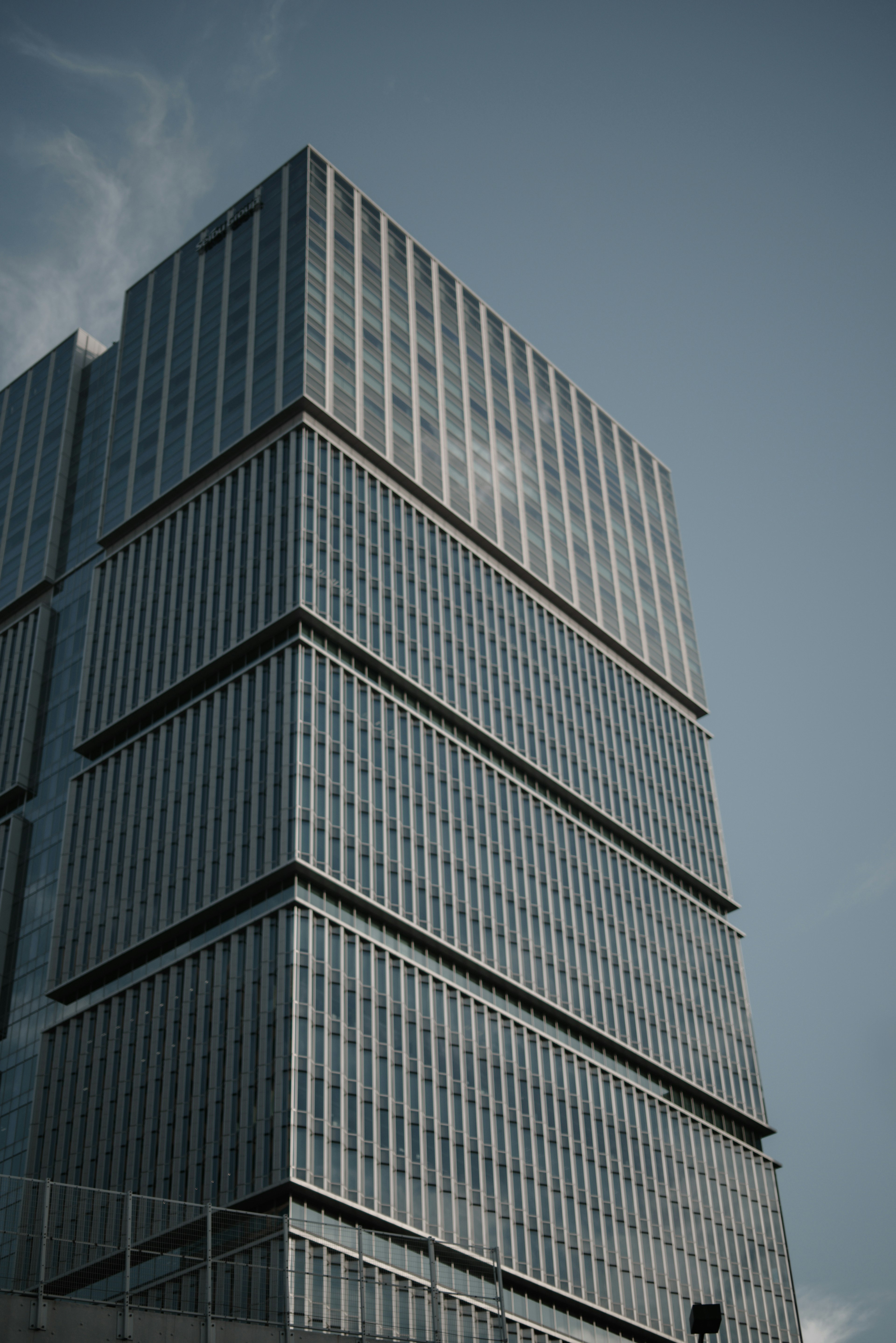 Edificio moderno visto desde un ángulo diagonal destacando la fachada de vidrio y las líneas