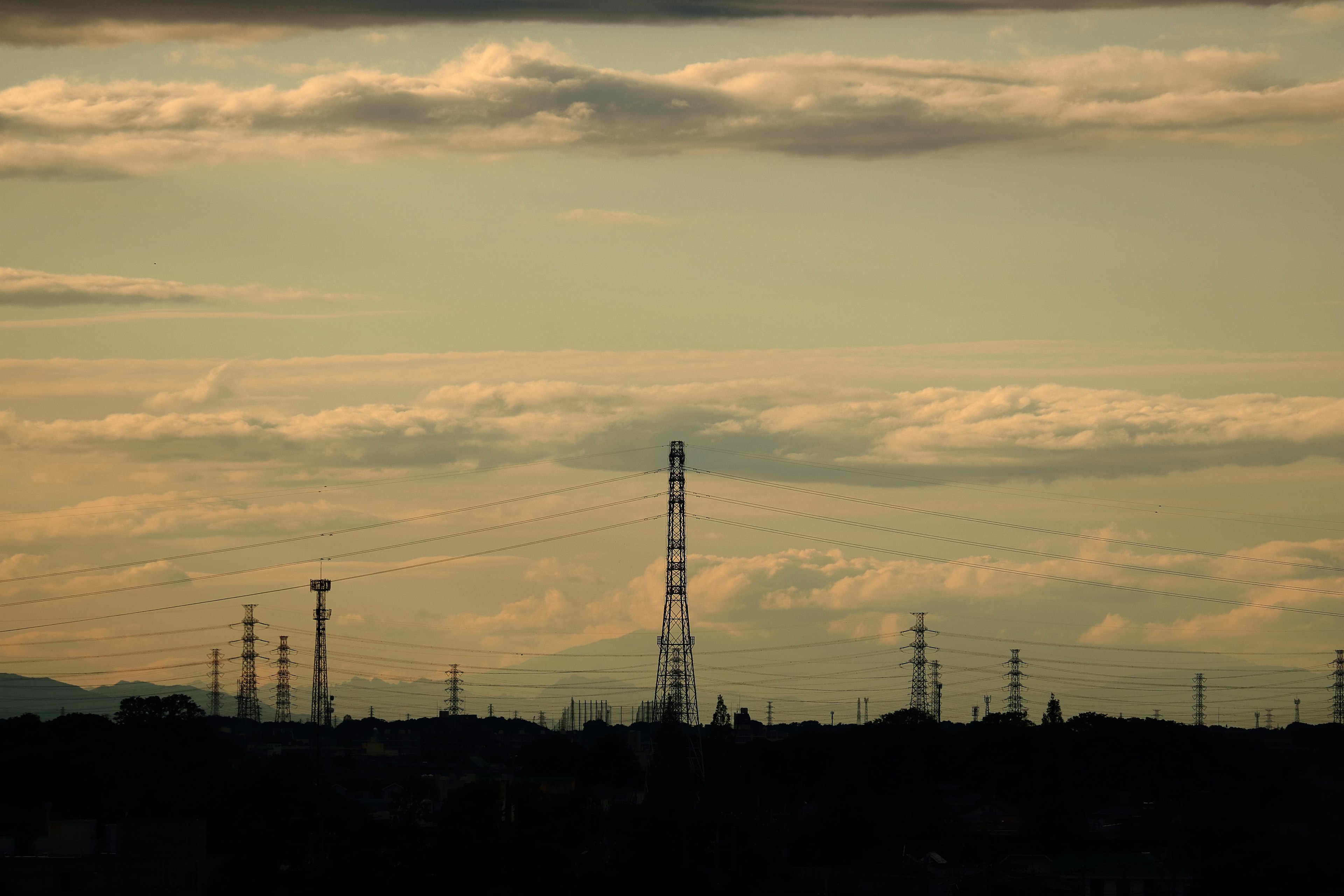 Torres de radio en silueta contra un cielo de atardecer con nubes