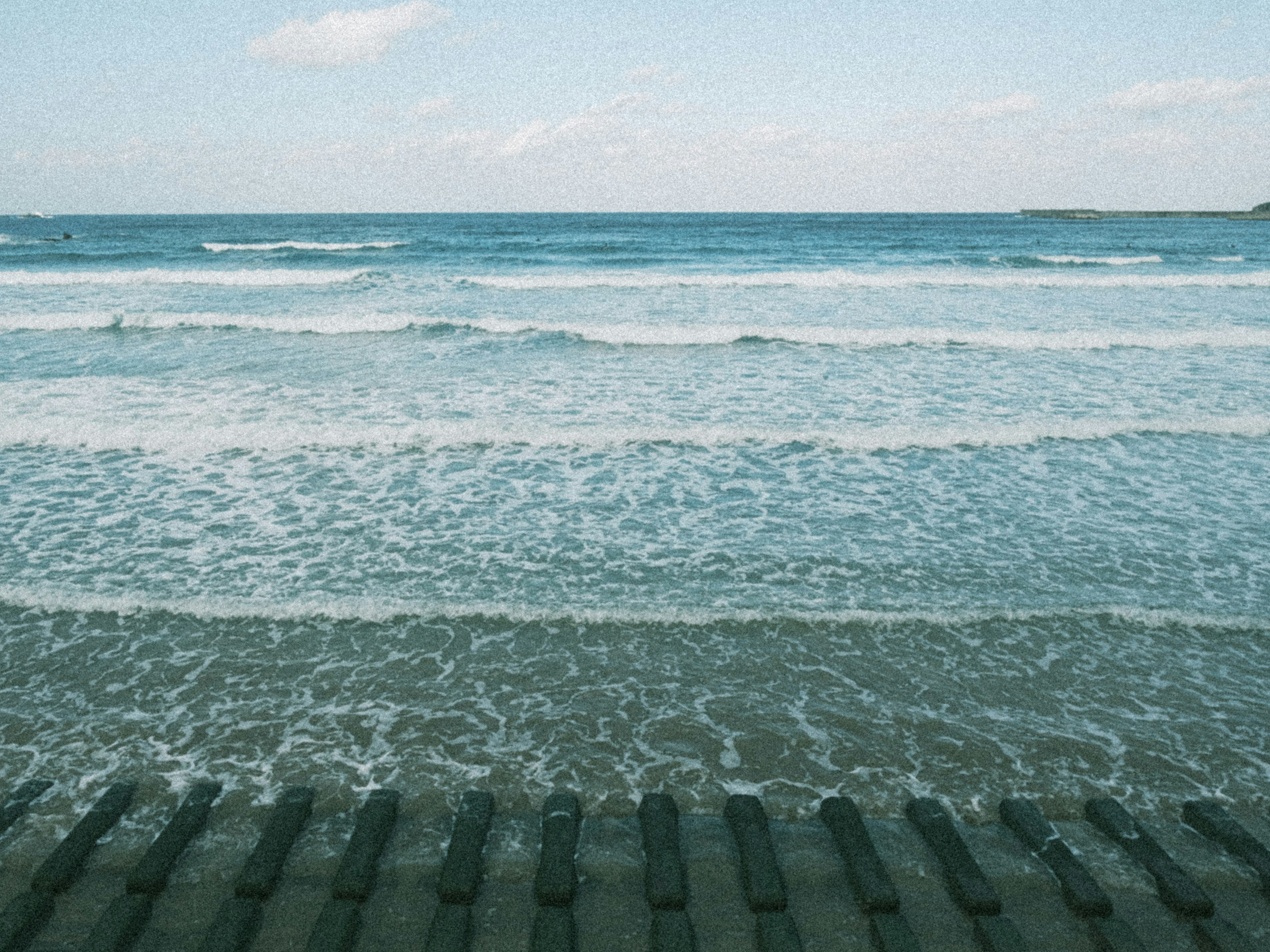 寧靜的海灘場景，波浪輕柔，藍色的海洋