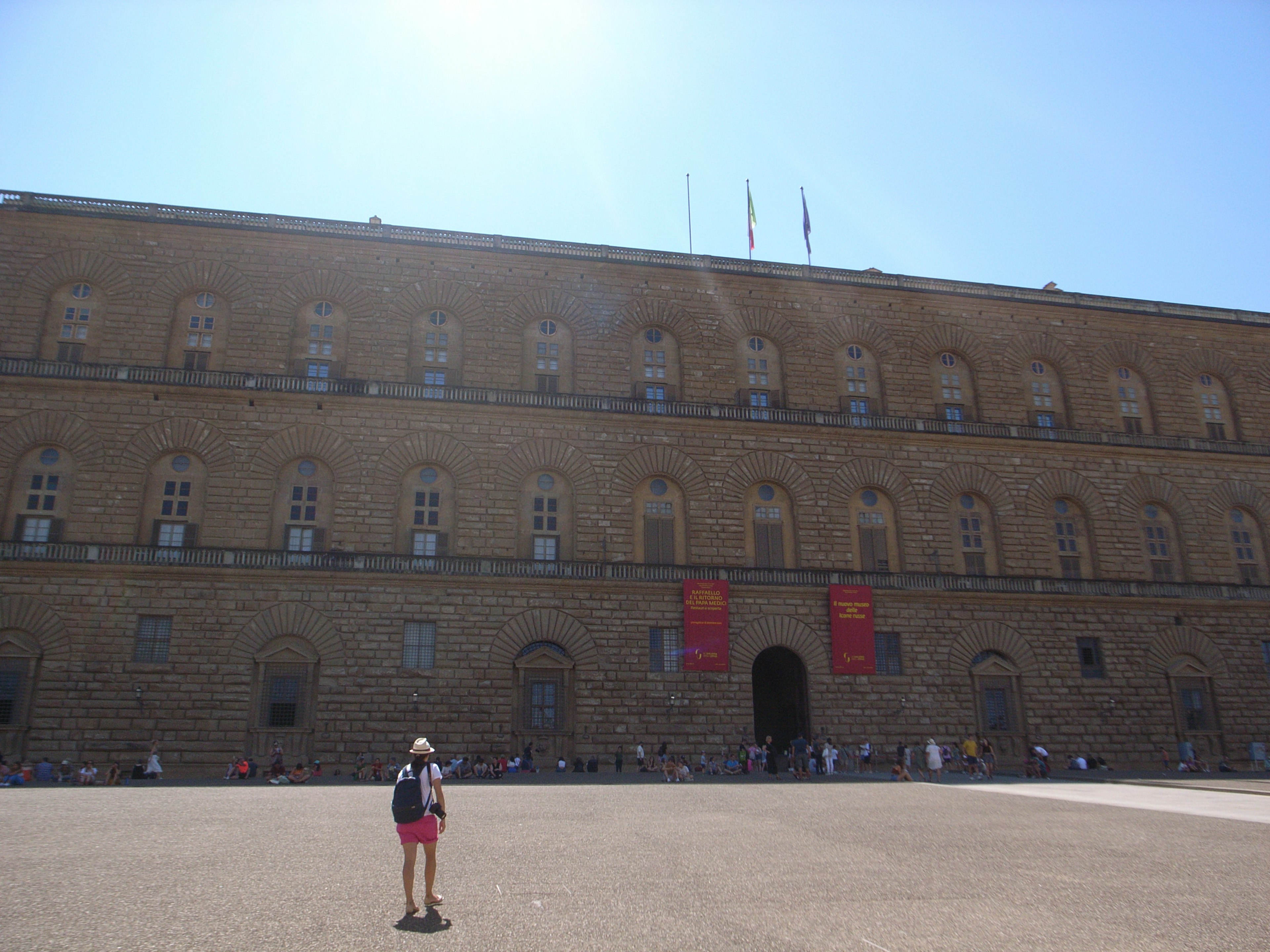 Exterior del Palacio Pitti en Florencia con un turista en la plaza