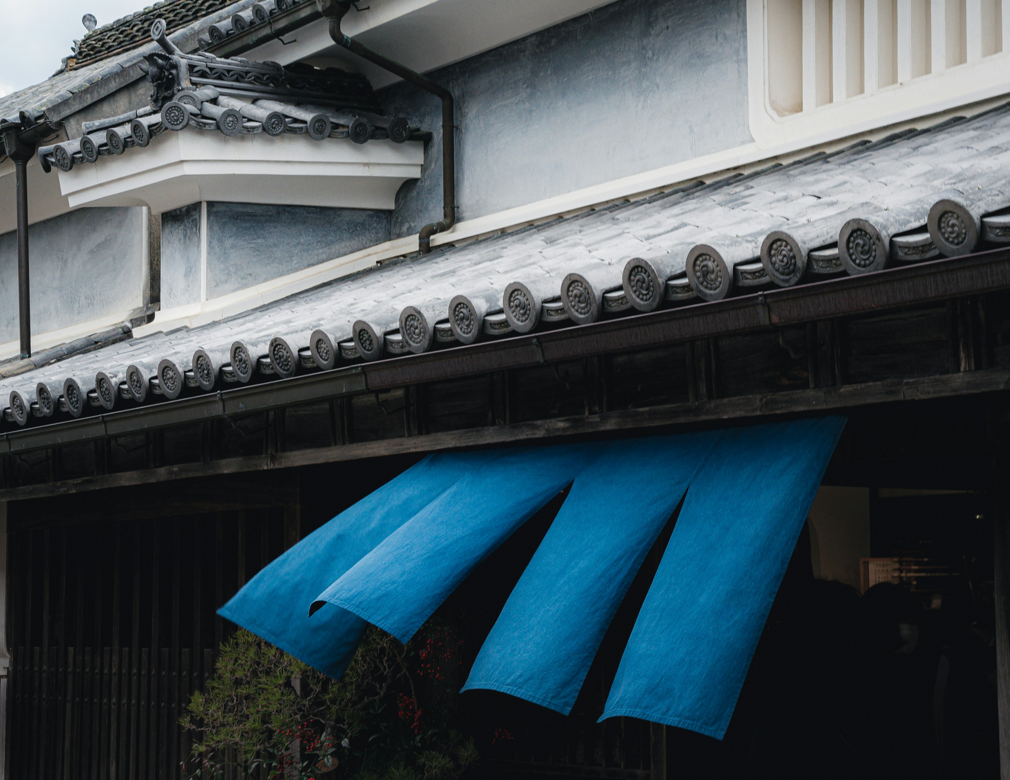 Fachada de un edificio japonés tradicional con toldo de tela azul