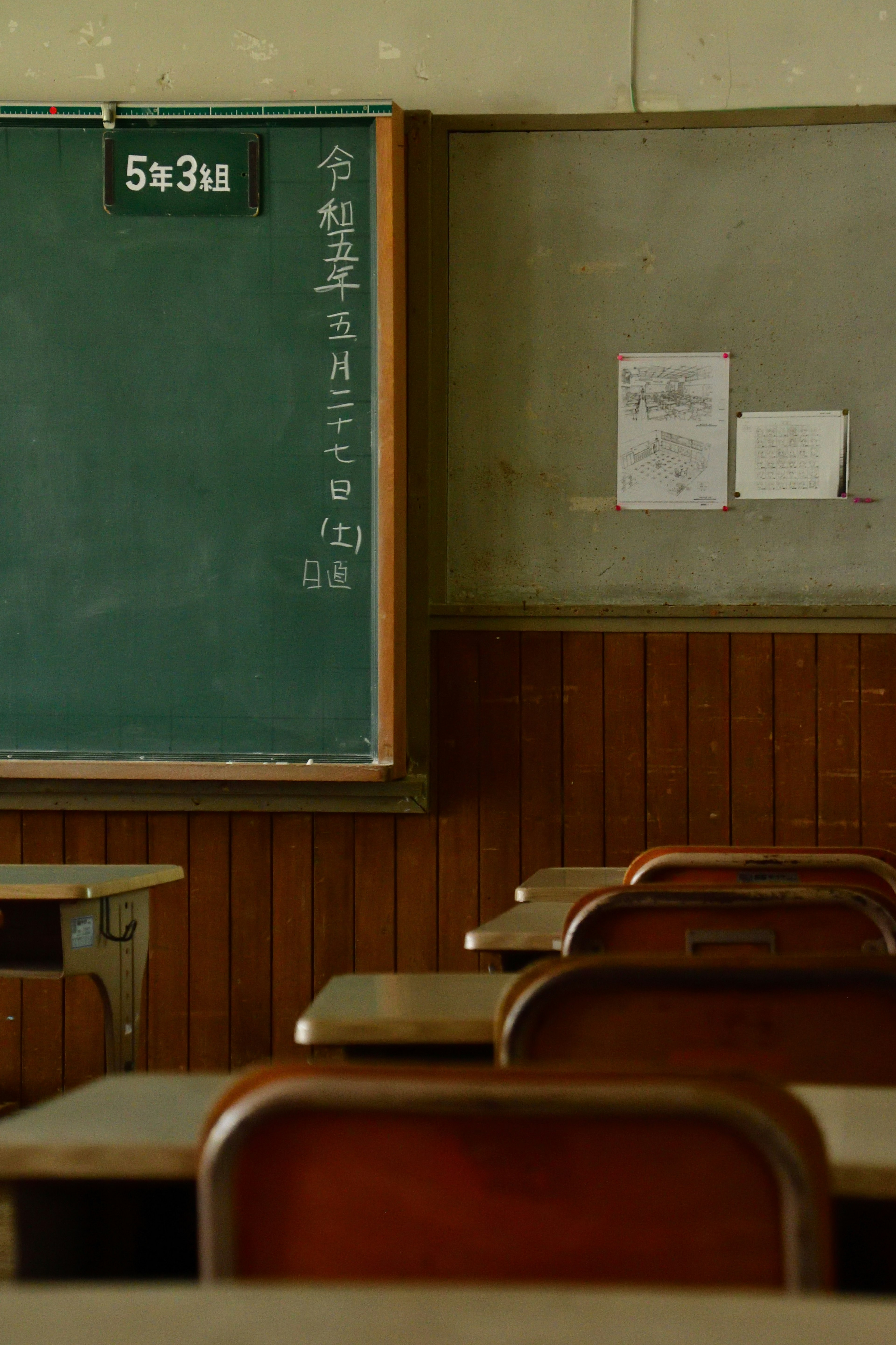 Quiet classroom scene with a chalkboard and desks