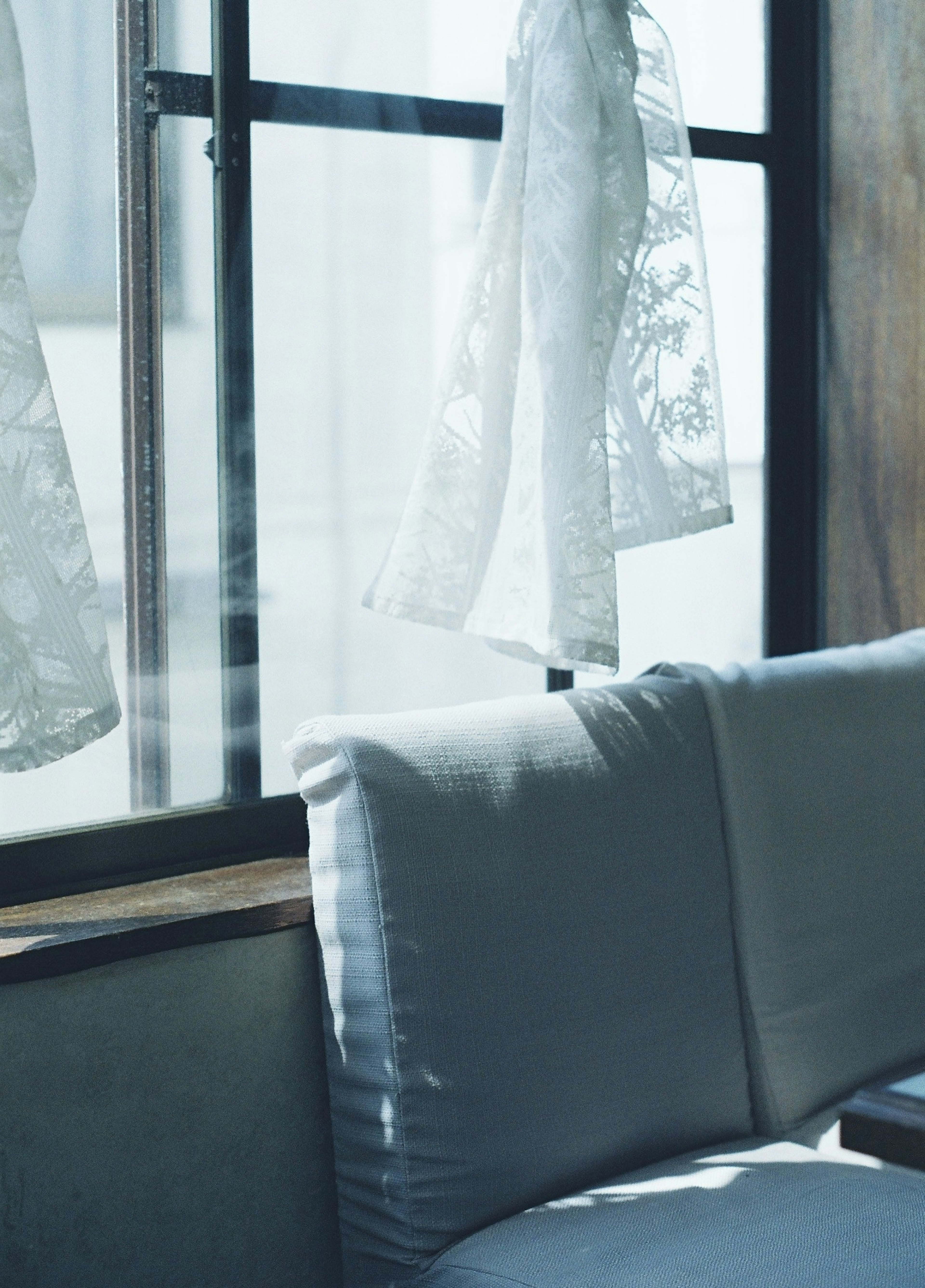 Bright sunlight streaming through a window with a white cushion and sheer curtains