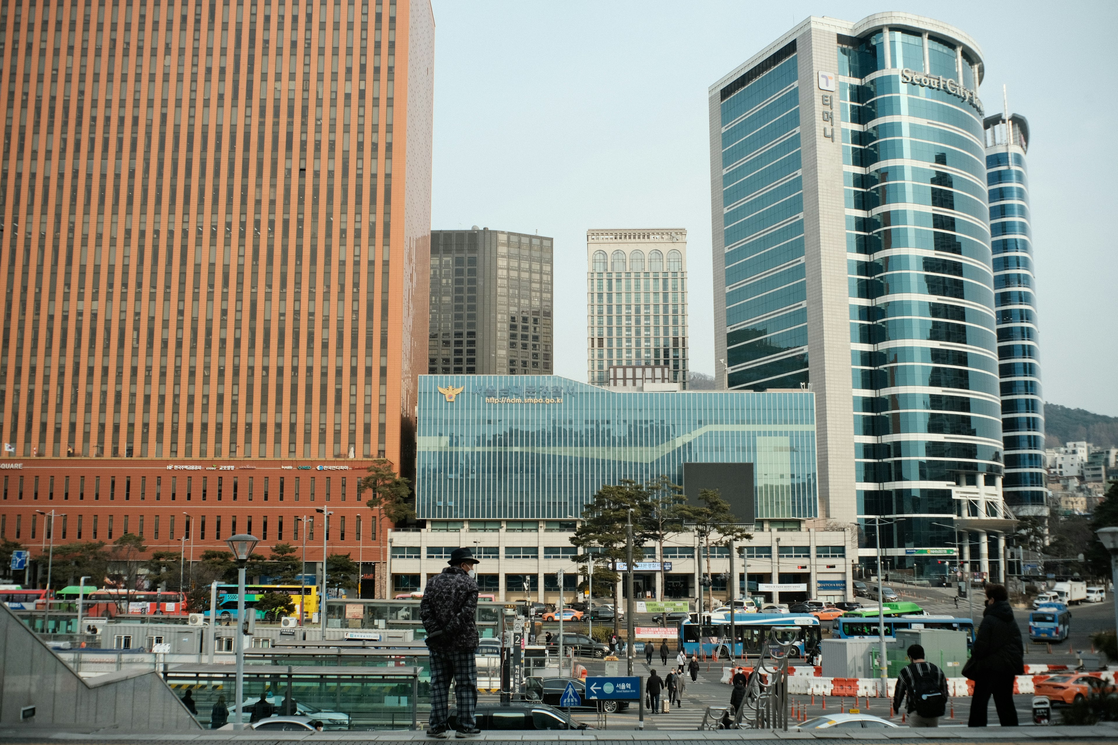 Pemandangan kota dengan gedung pencakar langit modern dan alun-alun yang ramai