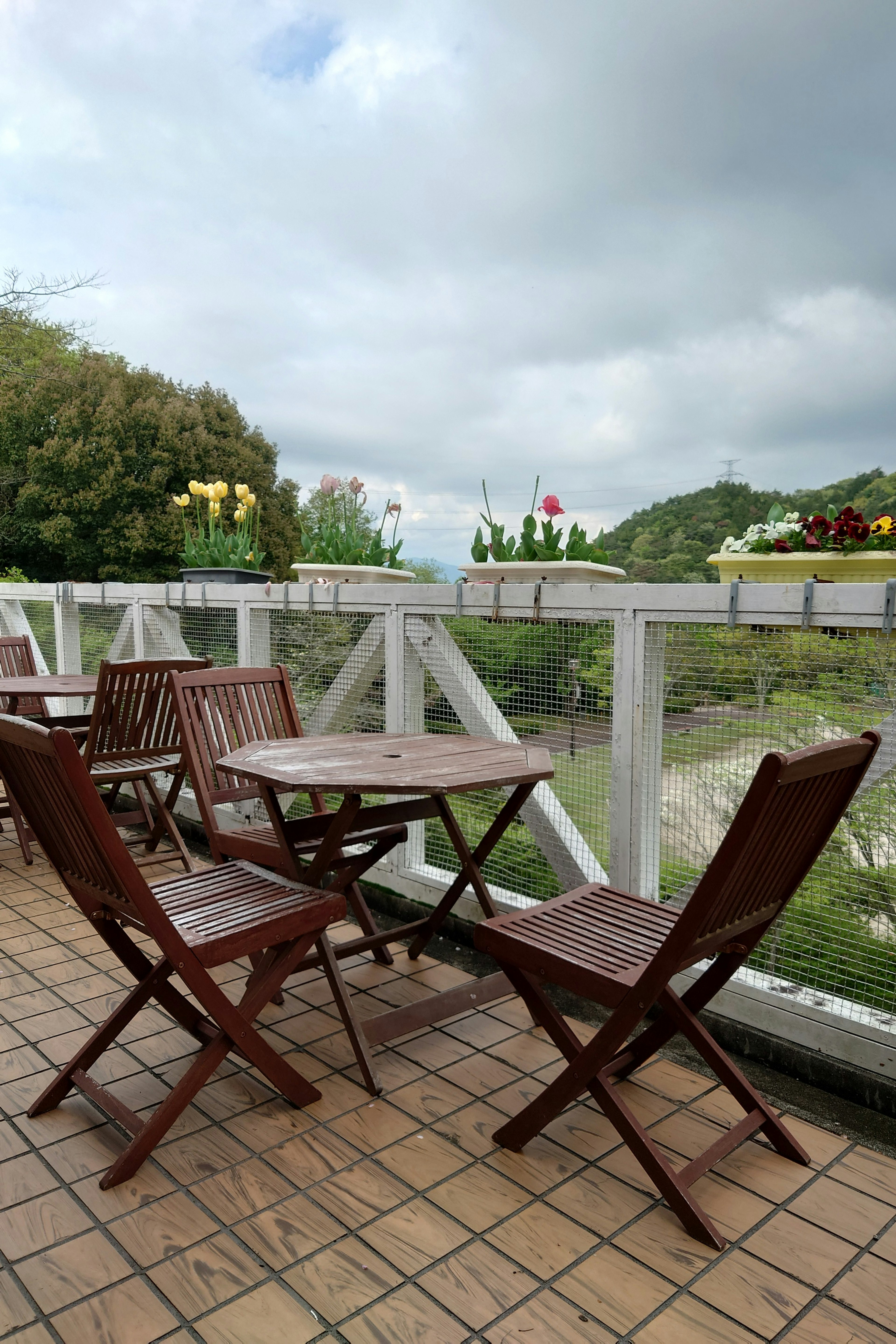 Wooden table and chairs on a balcony with a scenic view