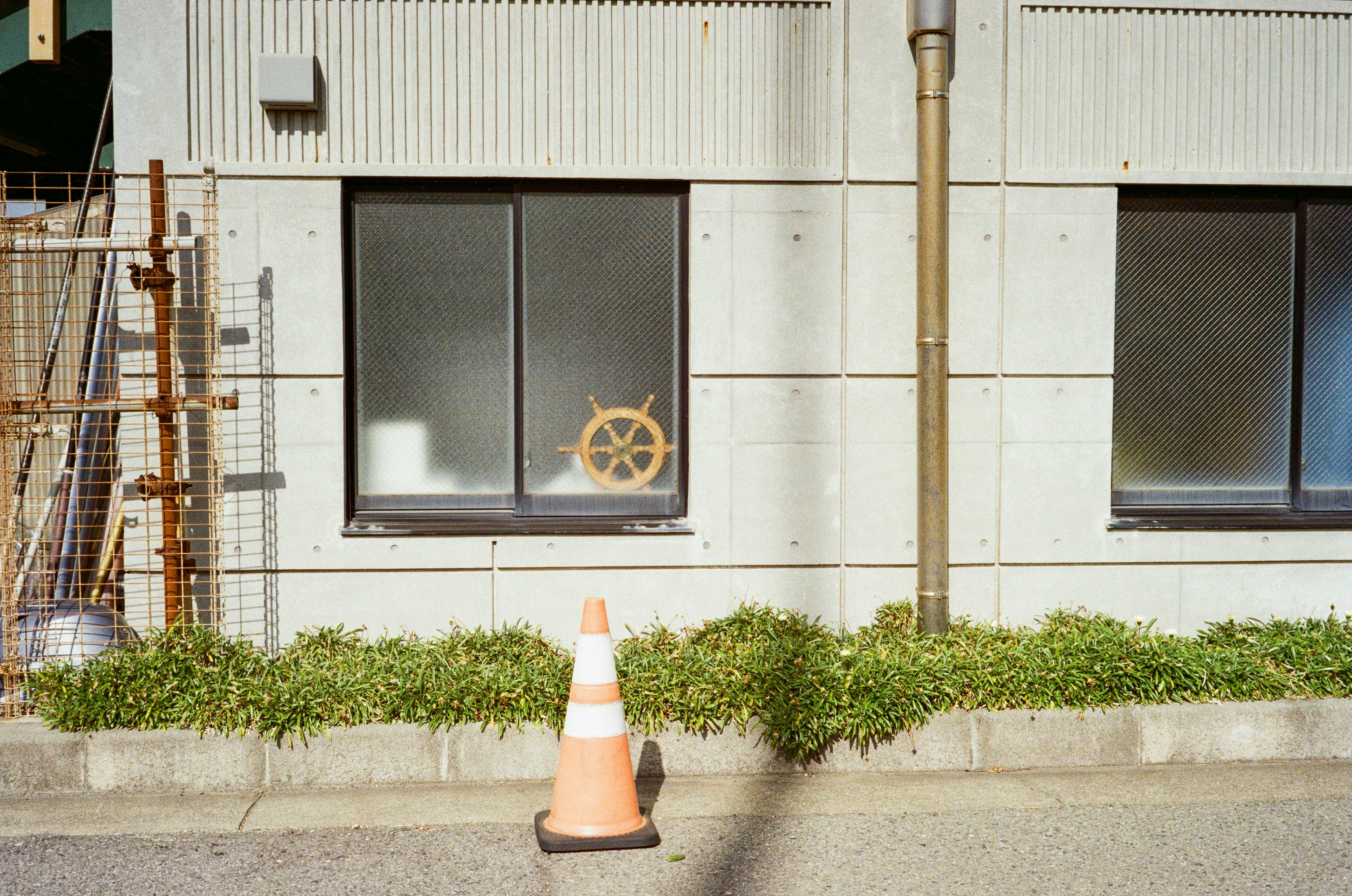 Window with a decorative ship's wheel in a concrete wall