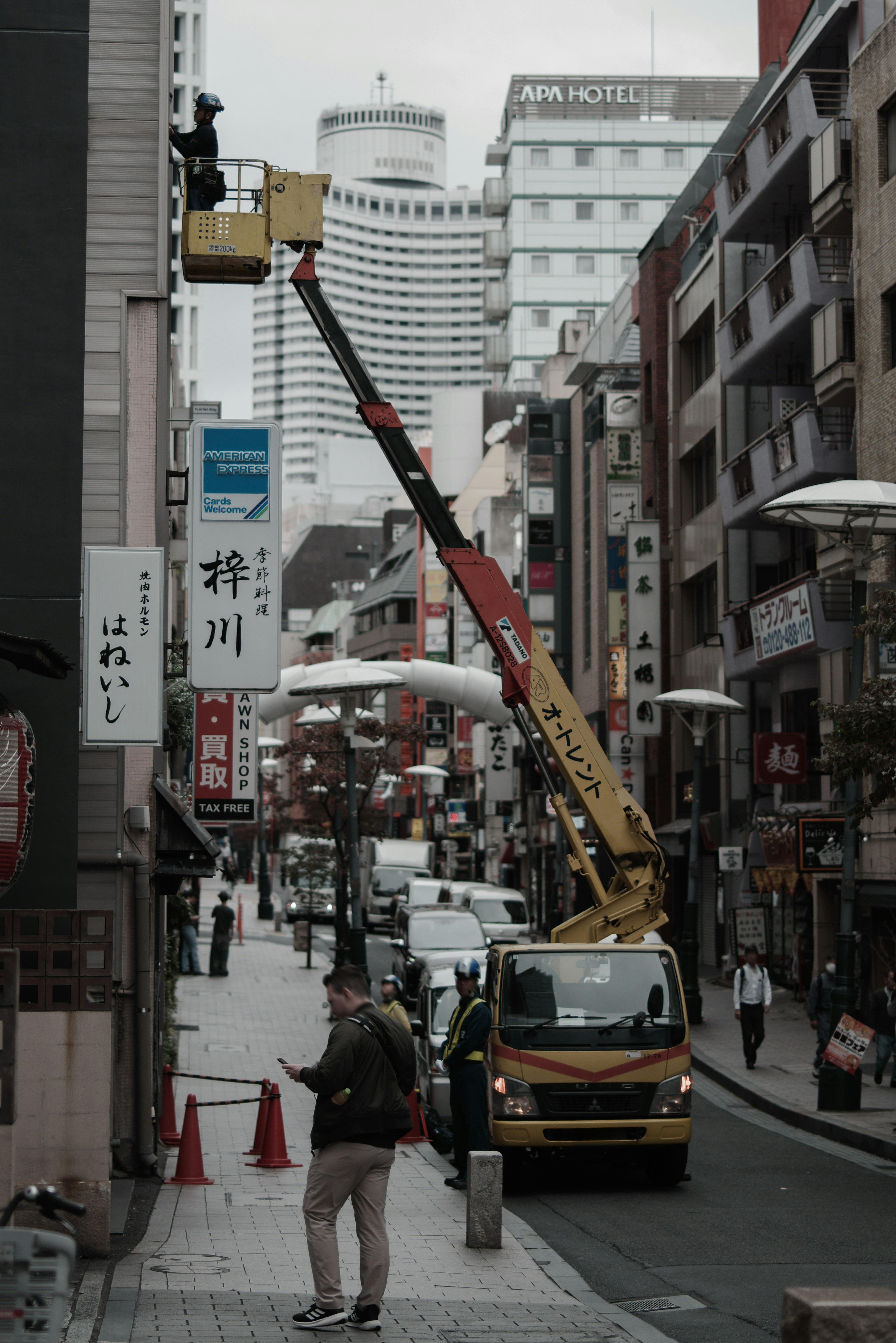 Scène de rue en ville avec une grue et un camion en action