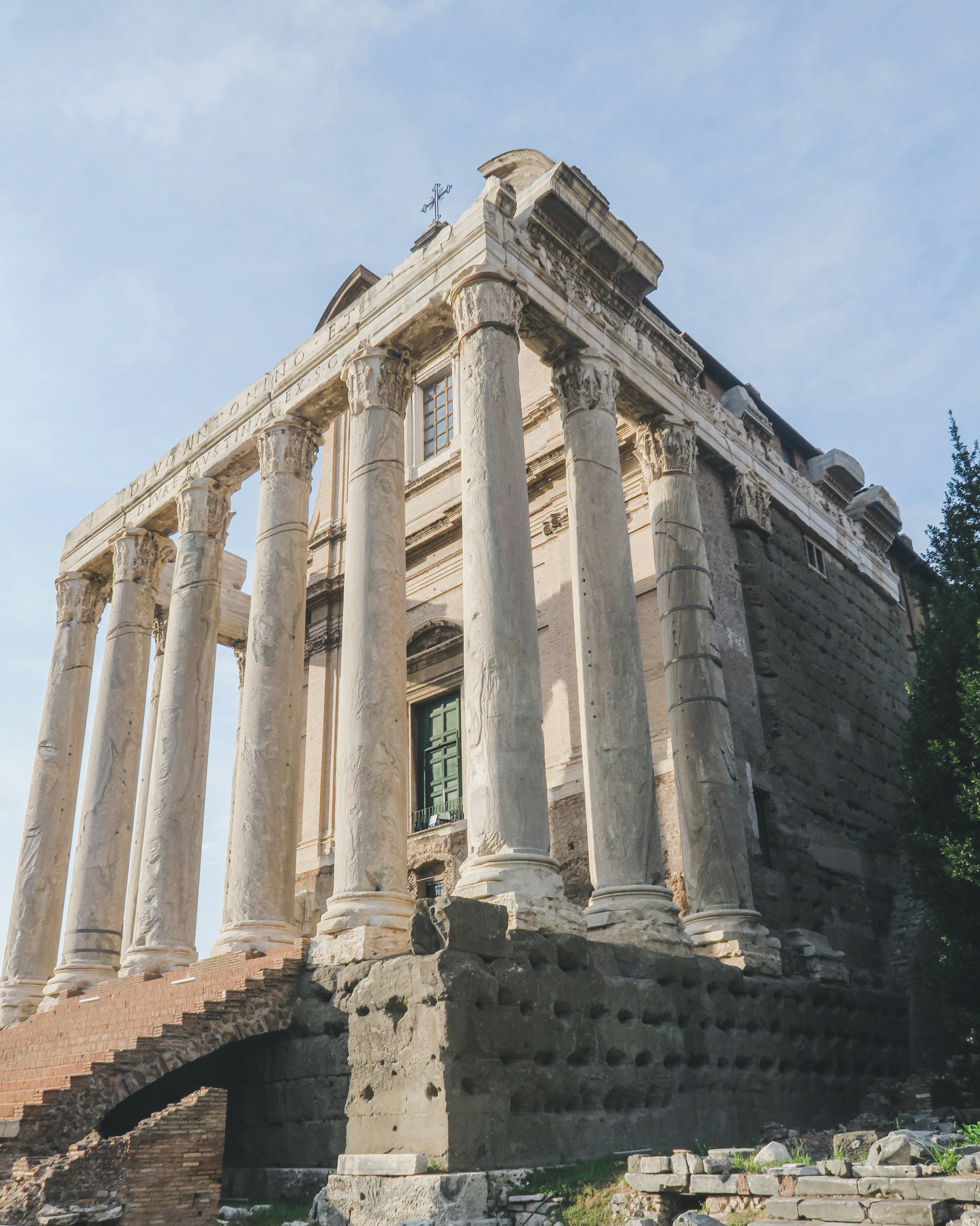 Ancient temple ruins with columns under a blue sky featuring stairs