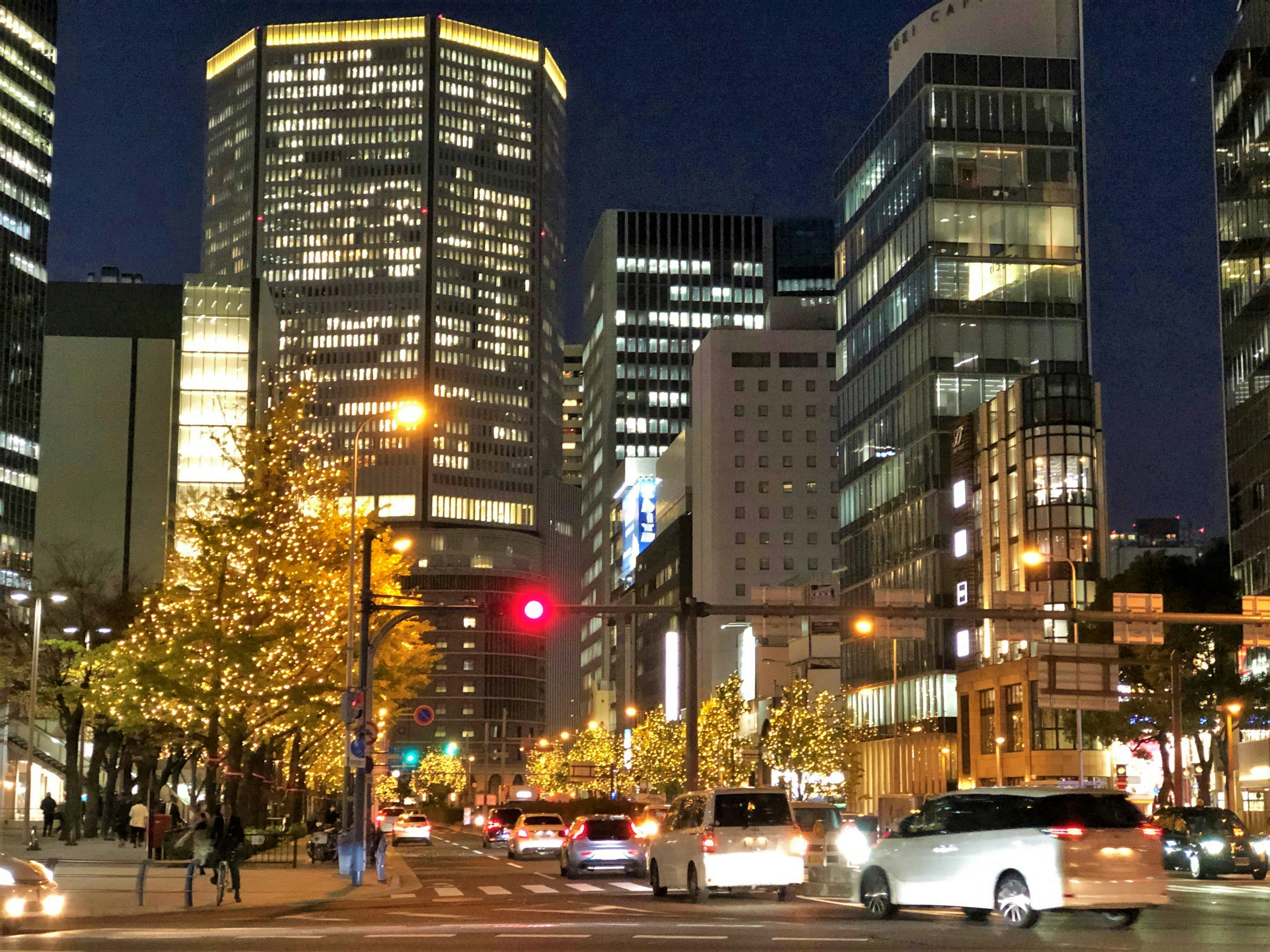 Paysage urbain nocturne avec des bâtiments lumineux et un feu de circulation