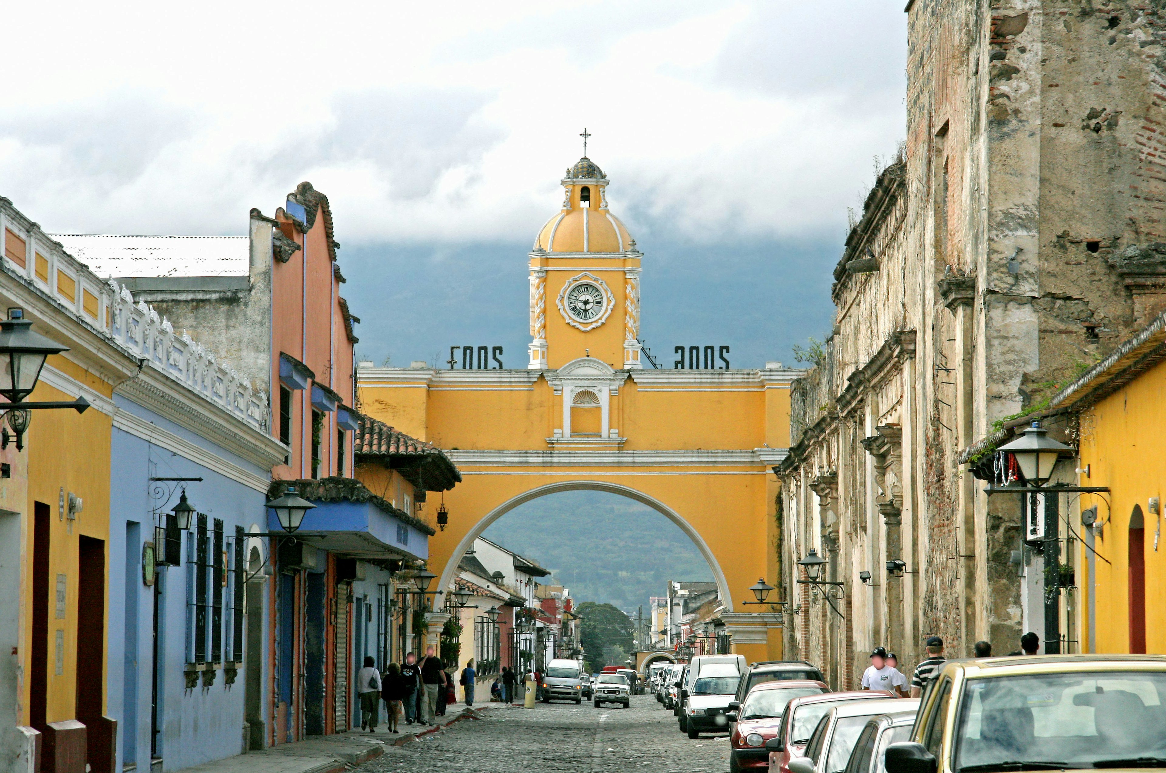 Vue de rue avec des bâtiments colorés et une horloge en arc