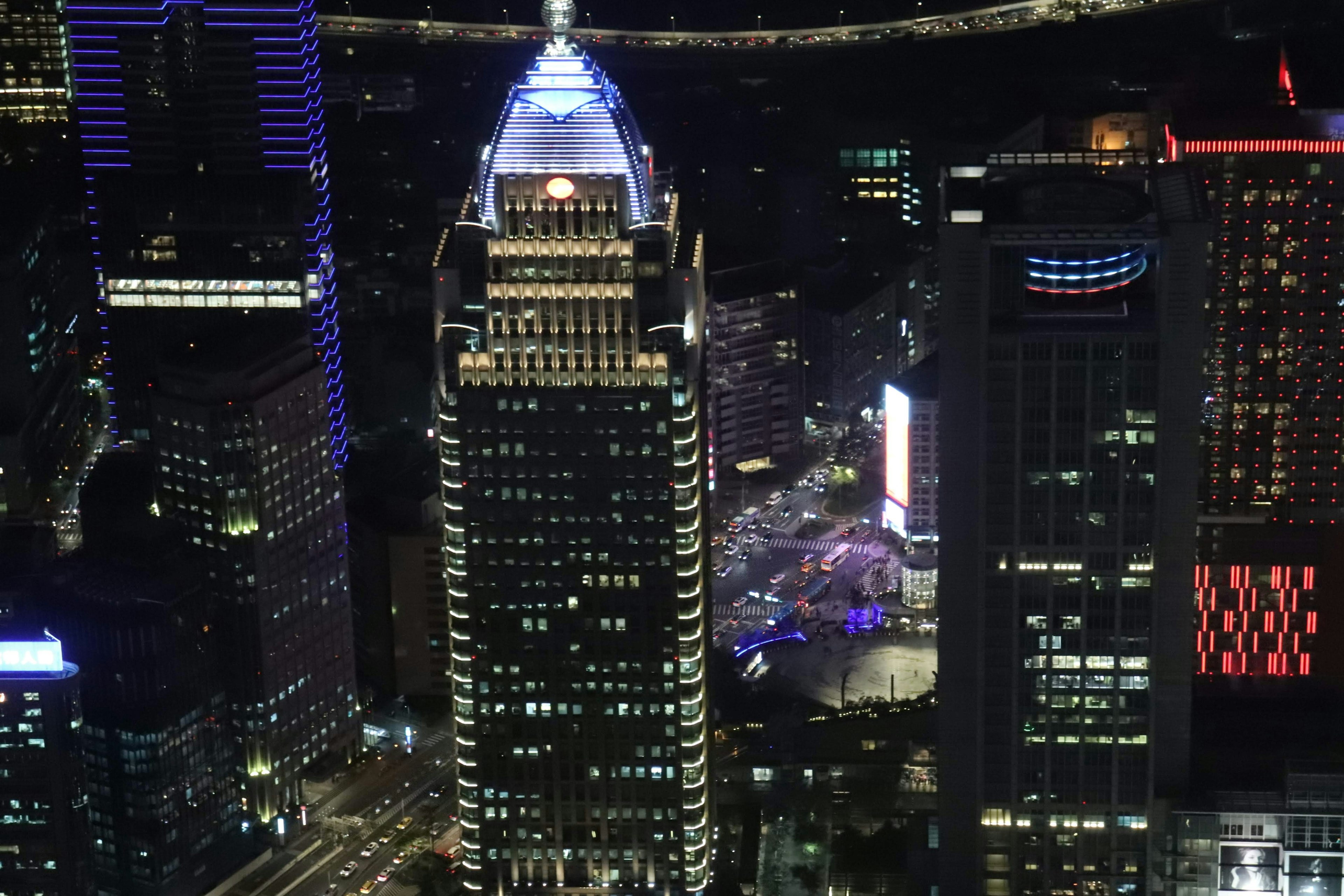 Vista nocturna de rascacielos con un edificio iluminado prominente