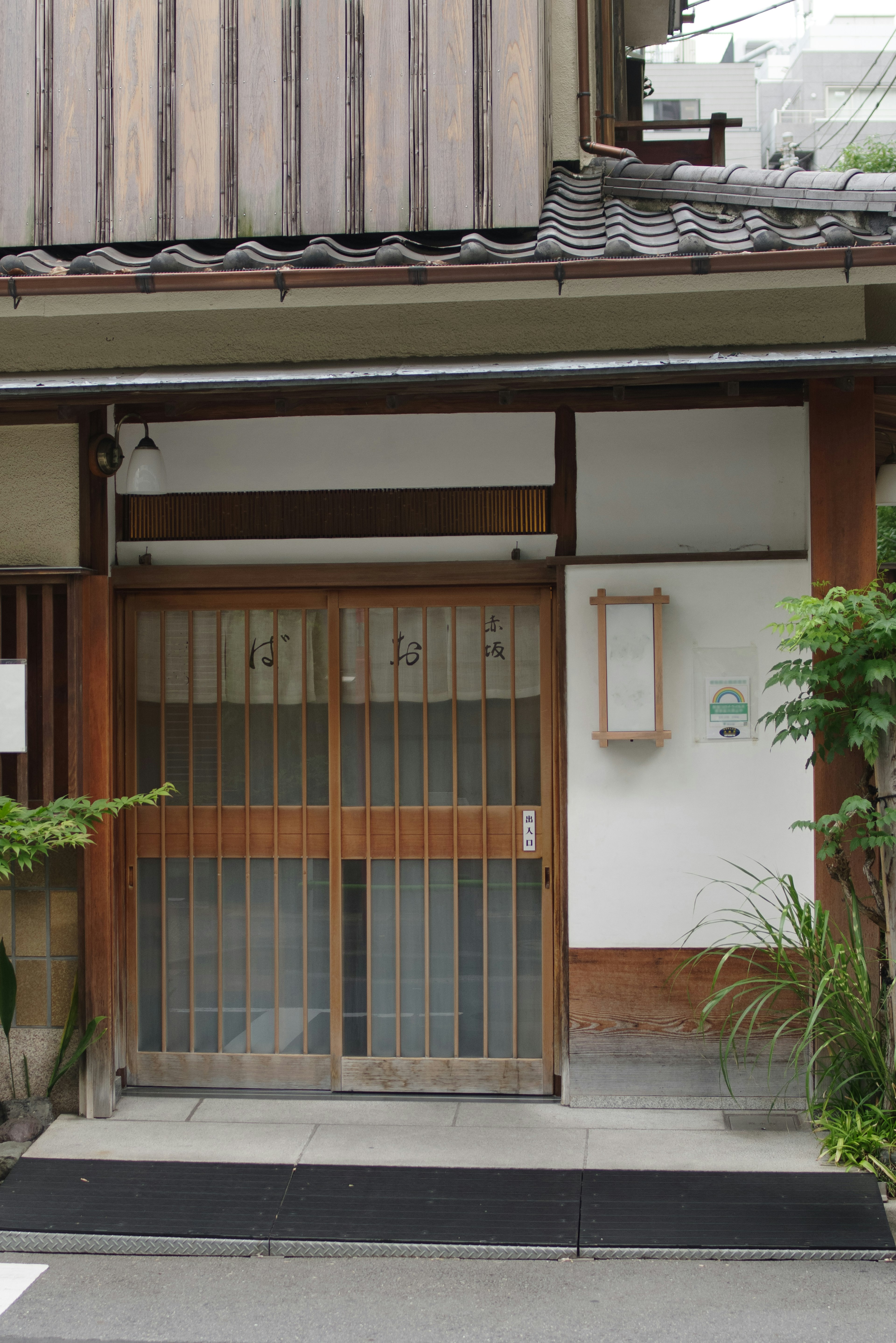 Rumah tradisional Jepang dengan pintu geser kayu dan tanaman hijau