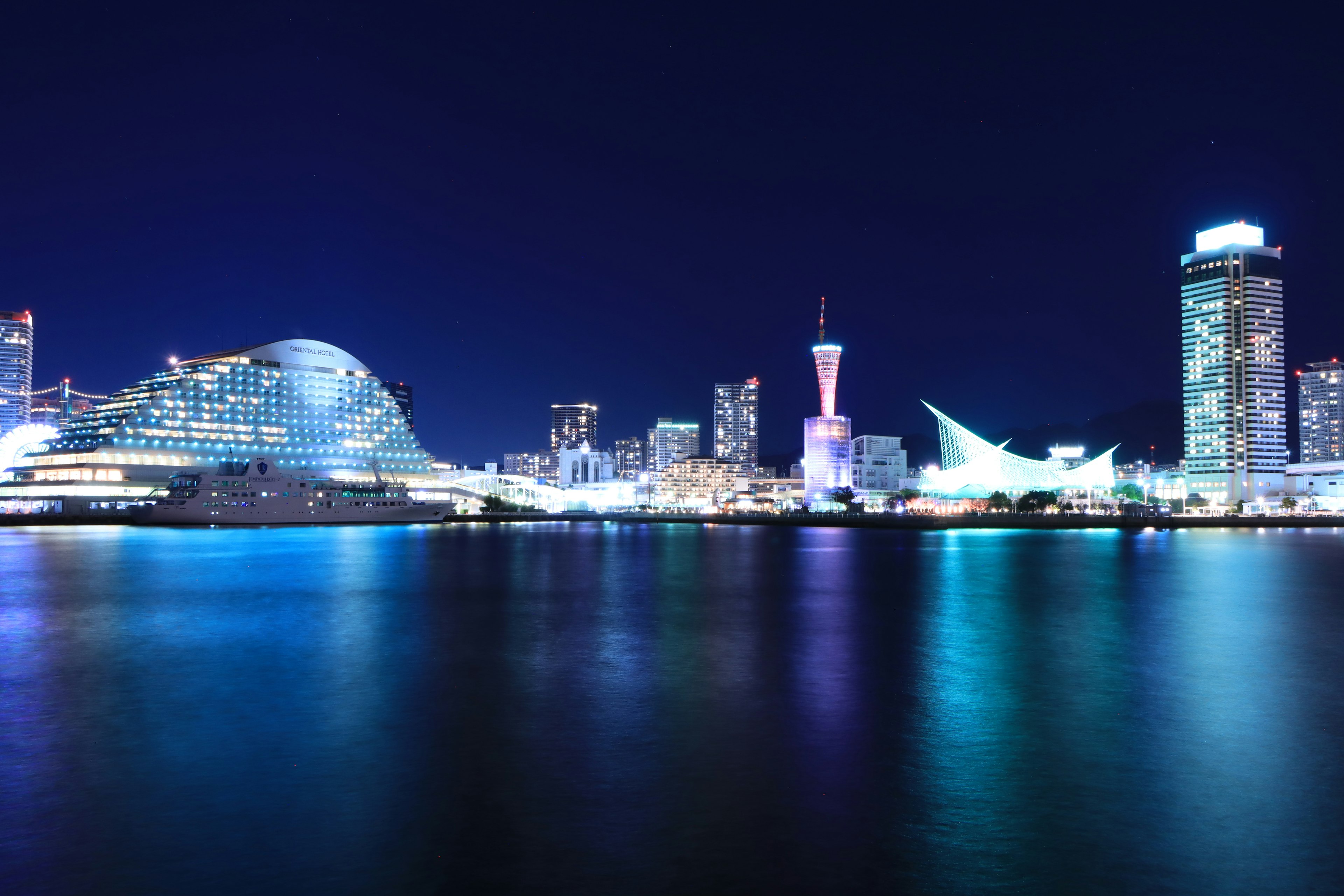 Horizonte de Yokohama de noche con reflejos en el agua