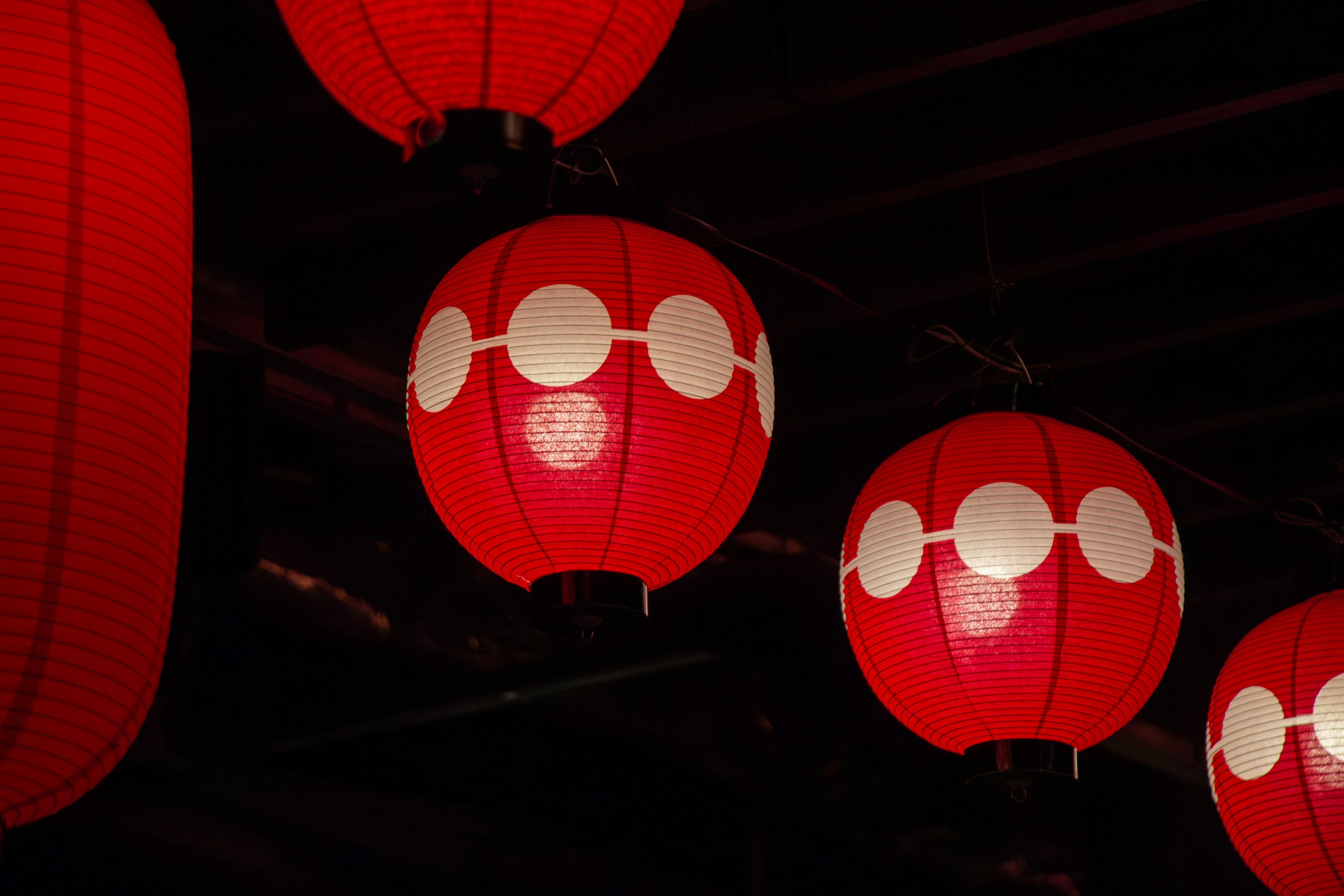 Lanternes rouges suspendues avec des motifs décoratifs blancs