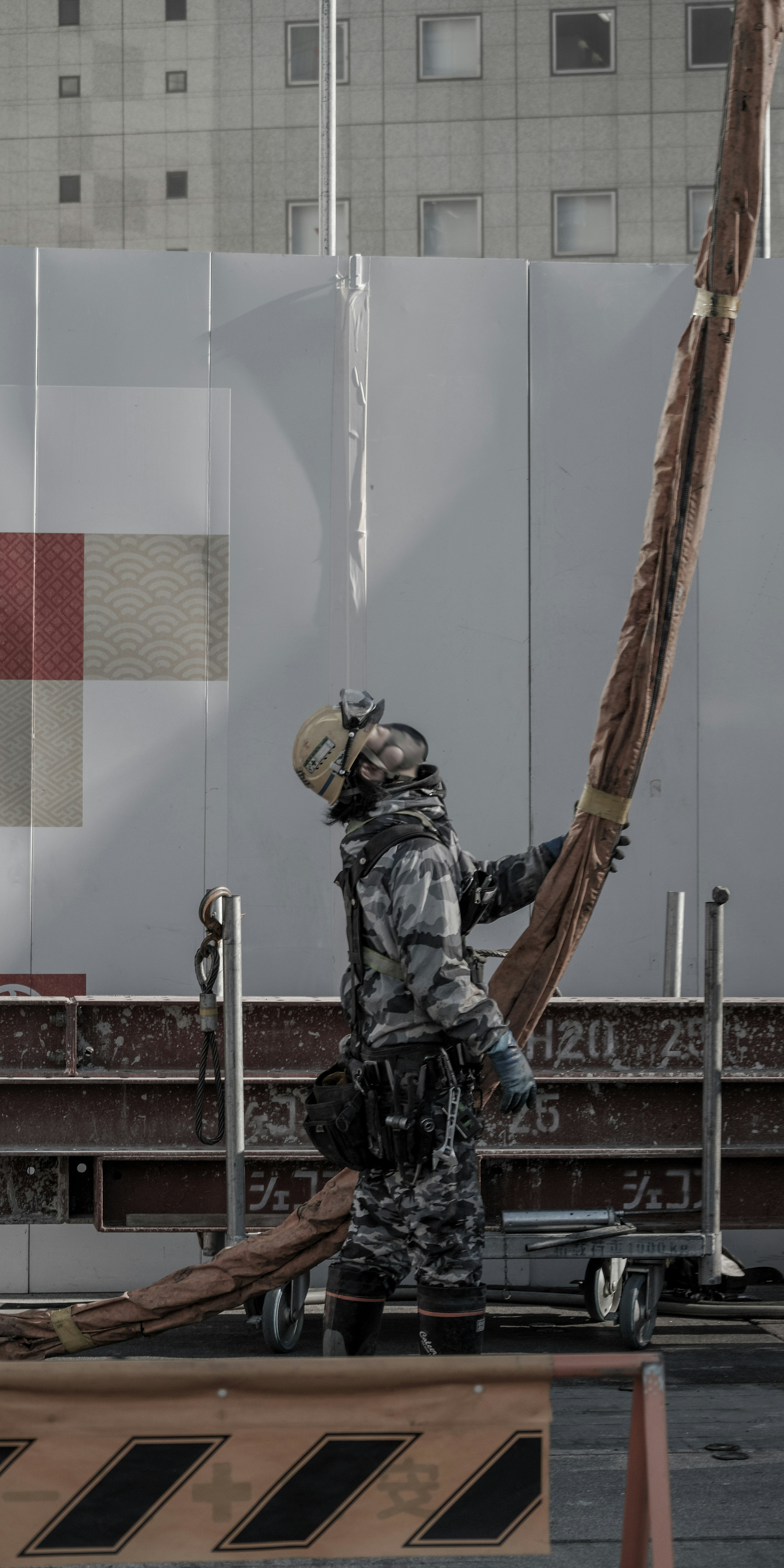 Worker holding a long piece of wood at a construction site