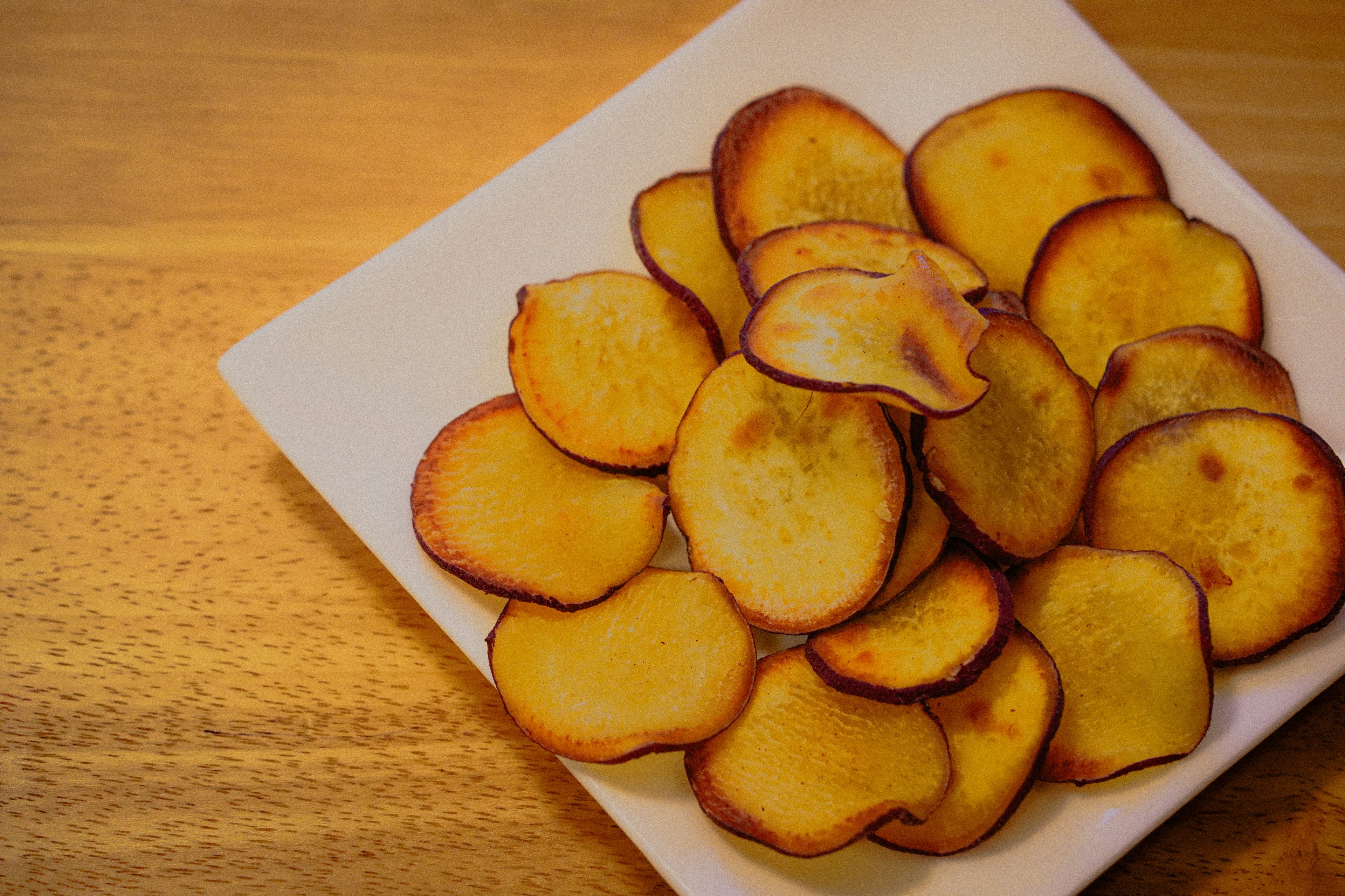 Crispy sweet potato chips arranged on a white plate