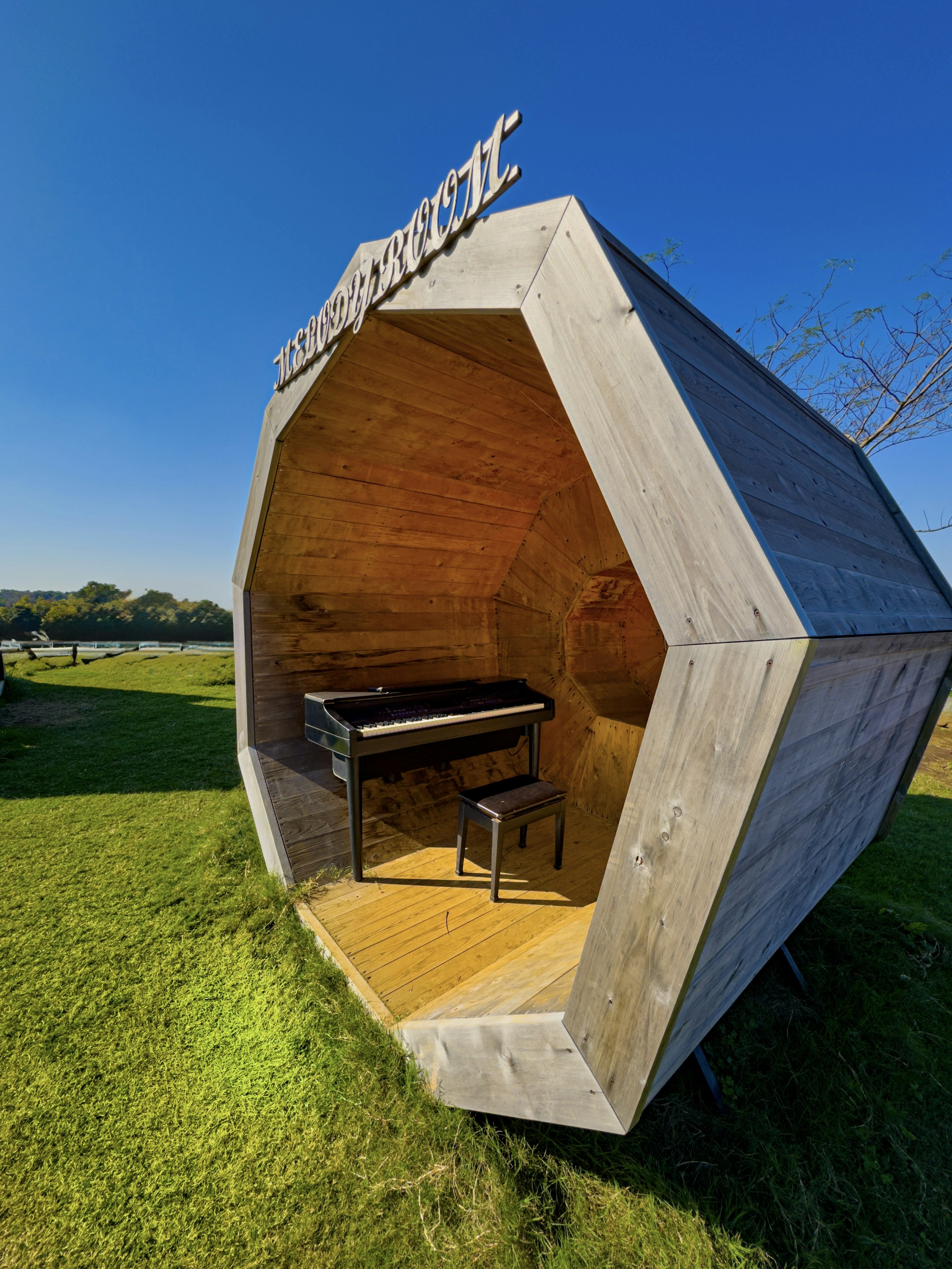 Unique hexagonal music hut featuring an interior piano