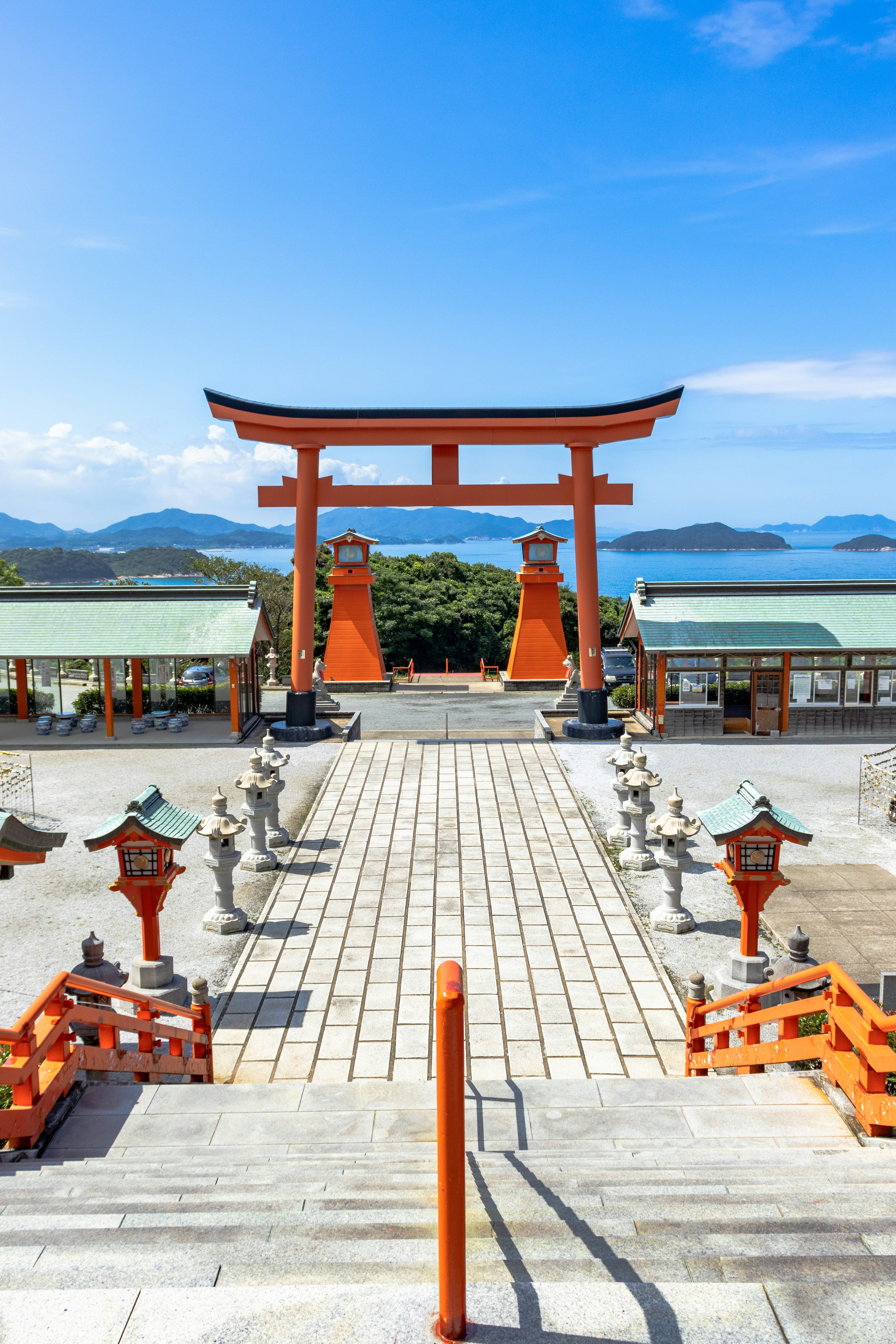 Vista escénica de un torii rojo con escalones de piedra bajo un cielo azul