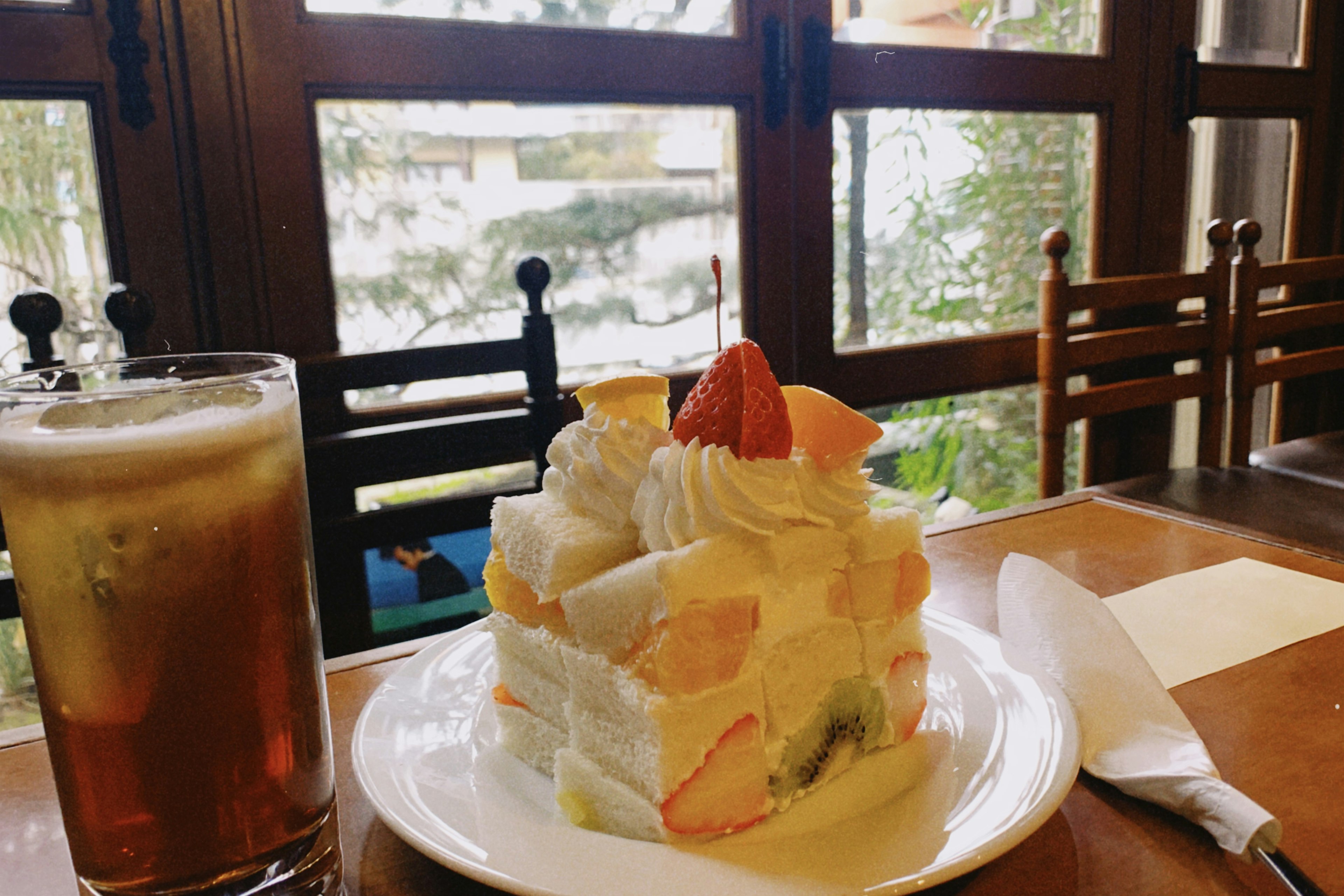 Obstkuchen und Bier auf einem Tisch am Fenster des Cafés