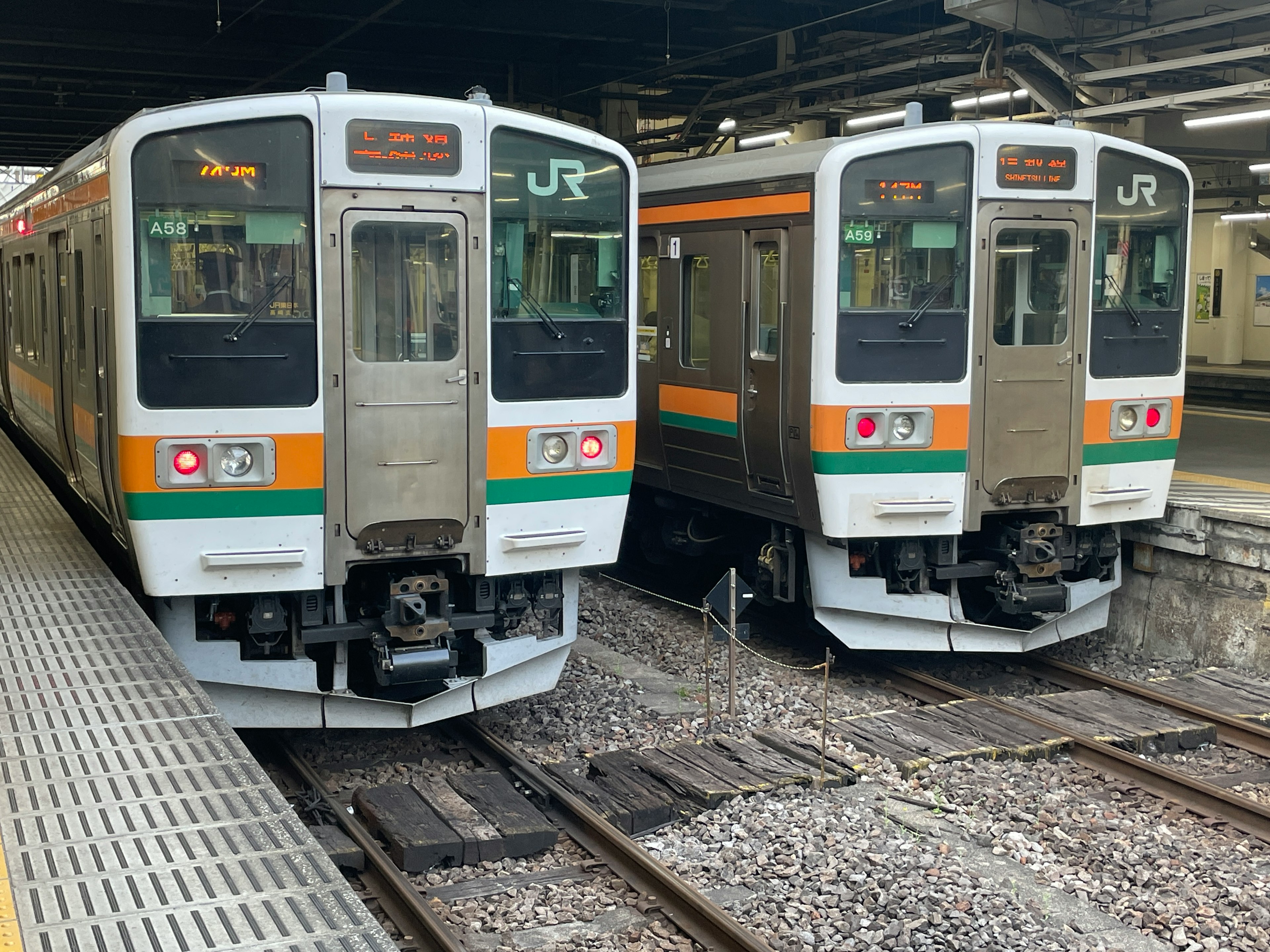 Dos trenes JR estacionados en una plataforma de estación