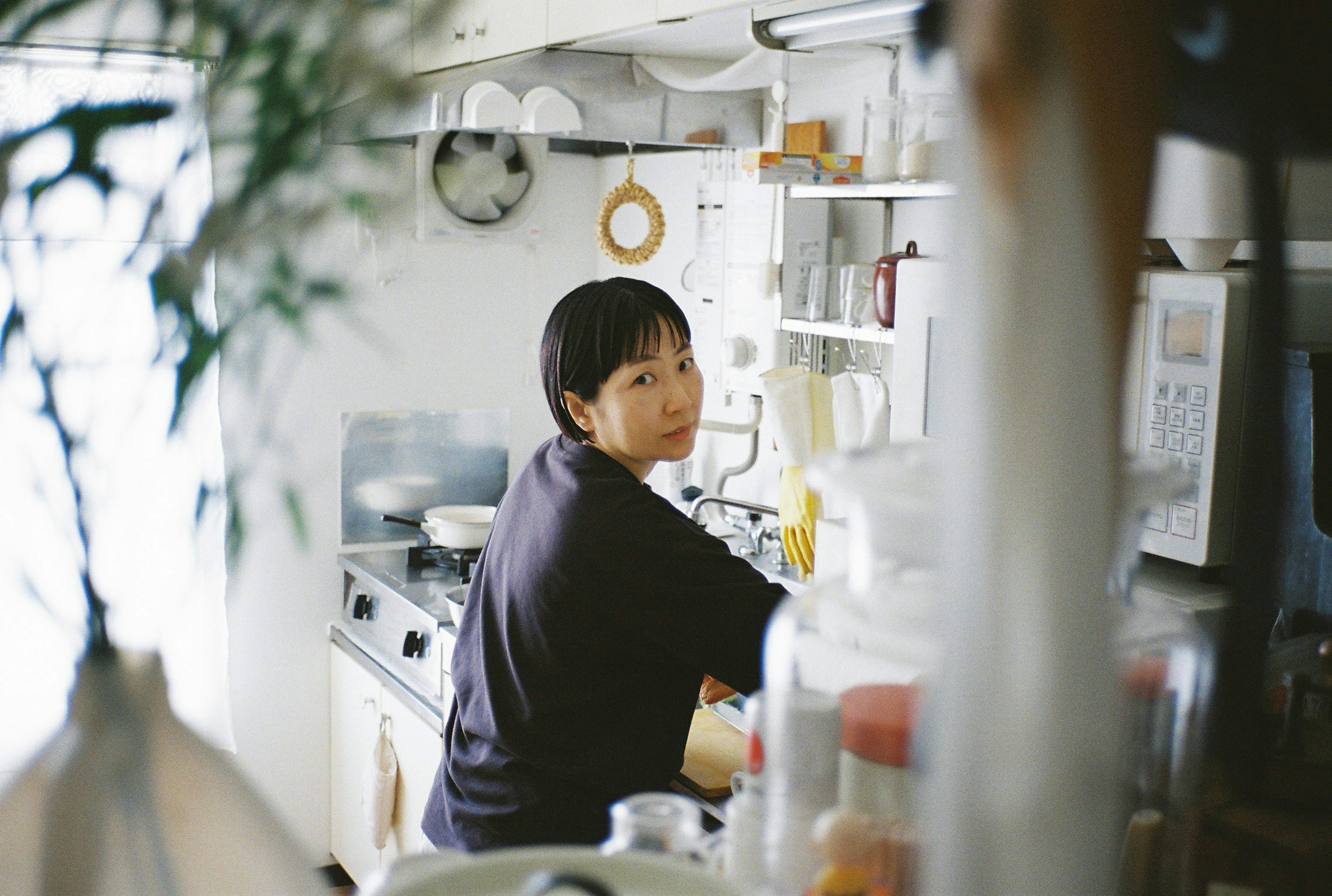 Woman cooking in a kitchen with bright interior and visible cooking utensils