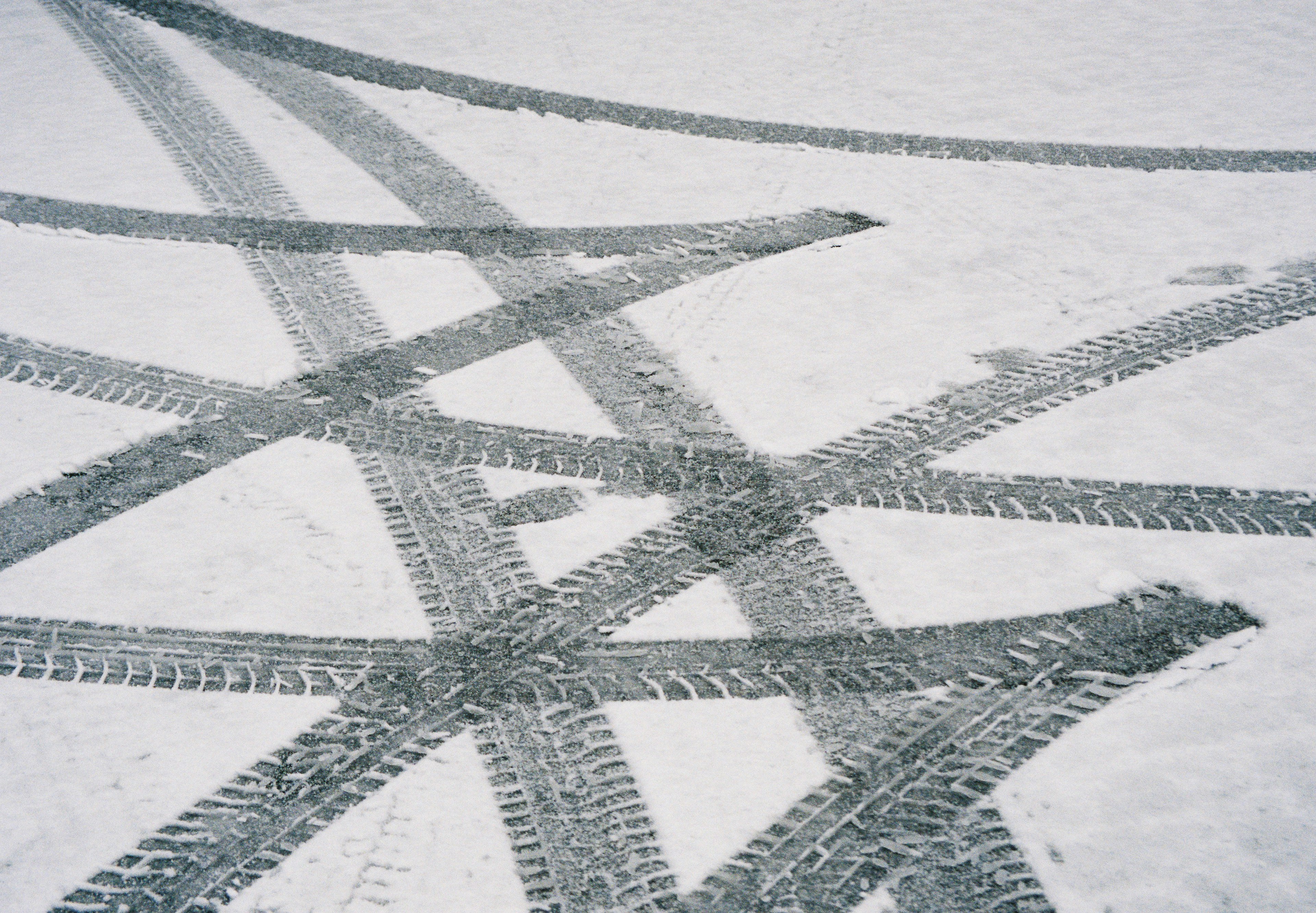 Intersecting tire tracks on a snowy surface